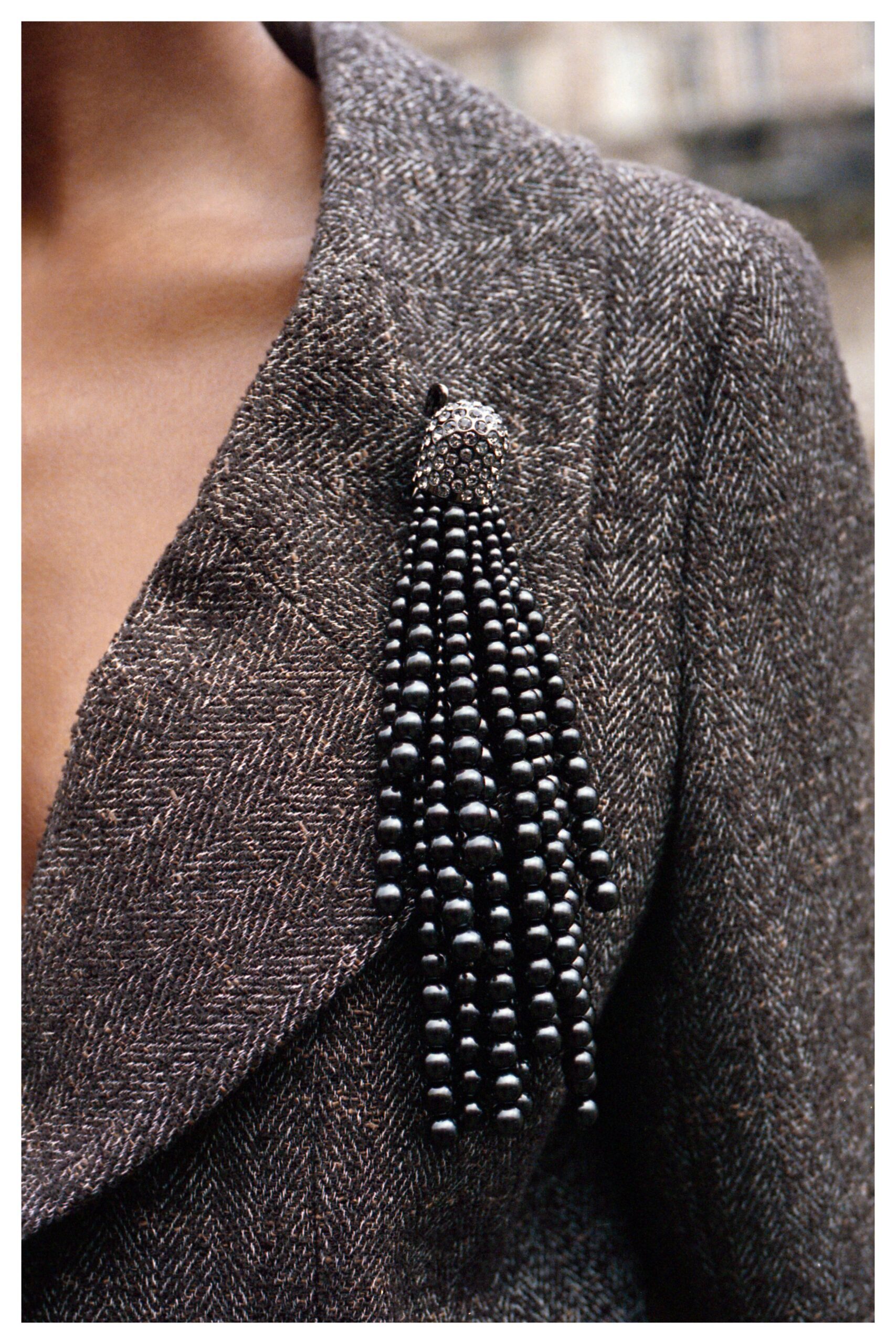 brown tweed blazer with beaded accessory