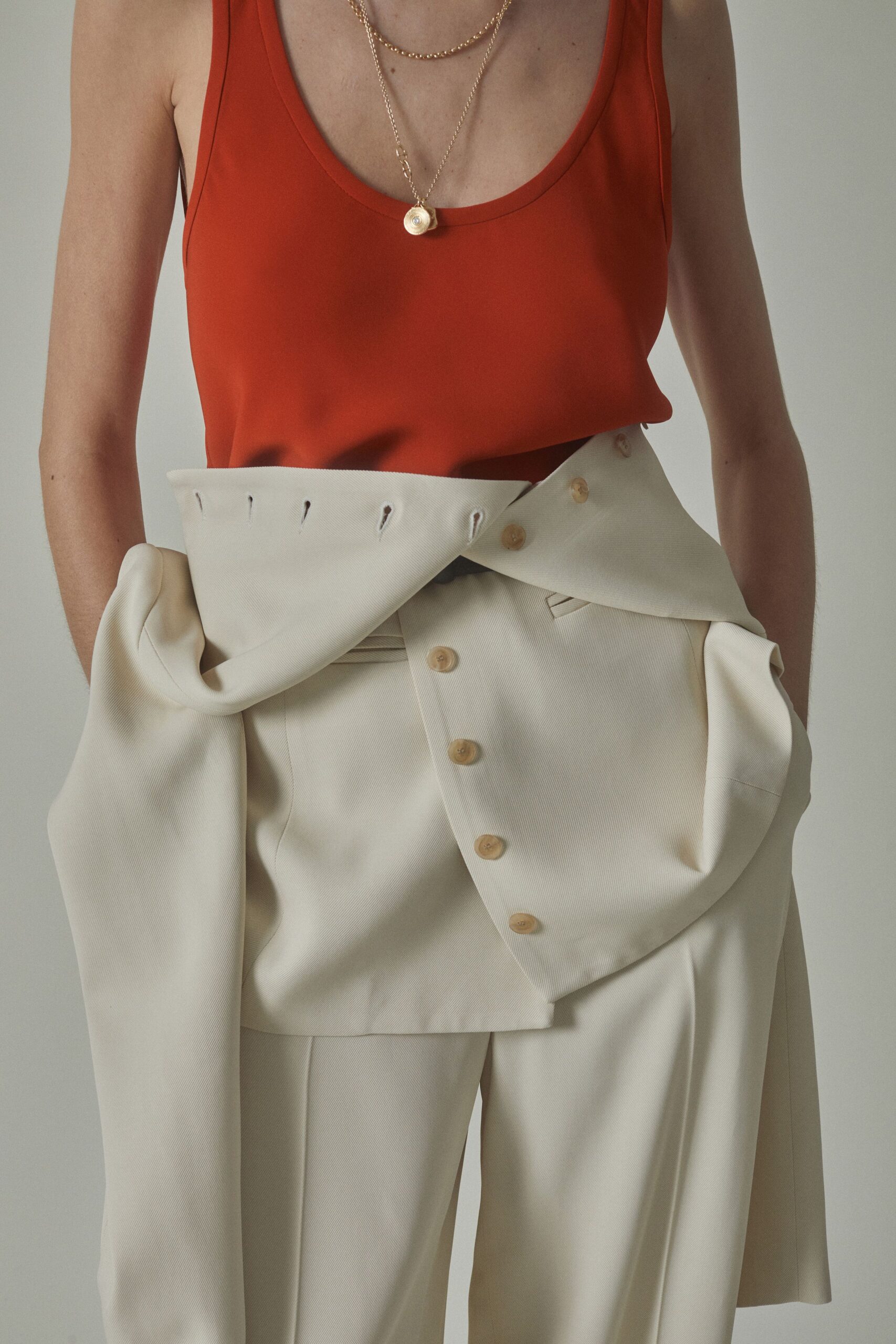red fitted sleeveless top and white relaxed pants