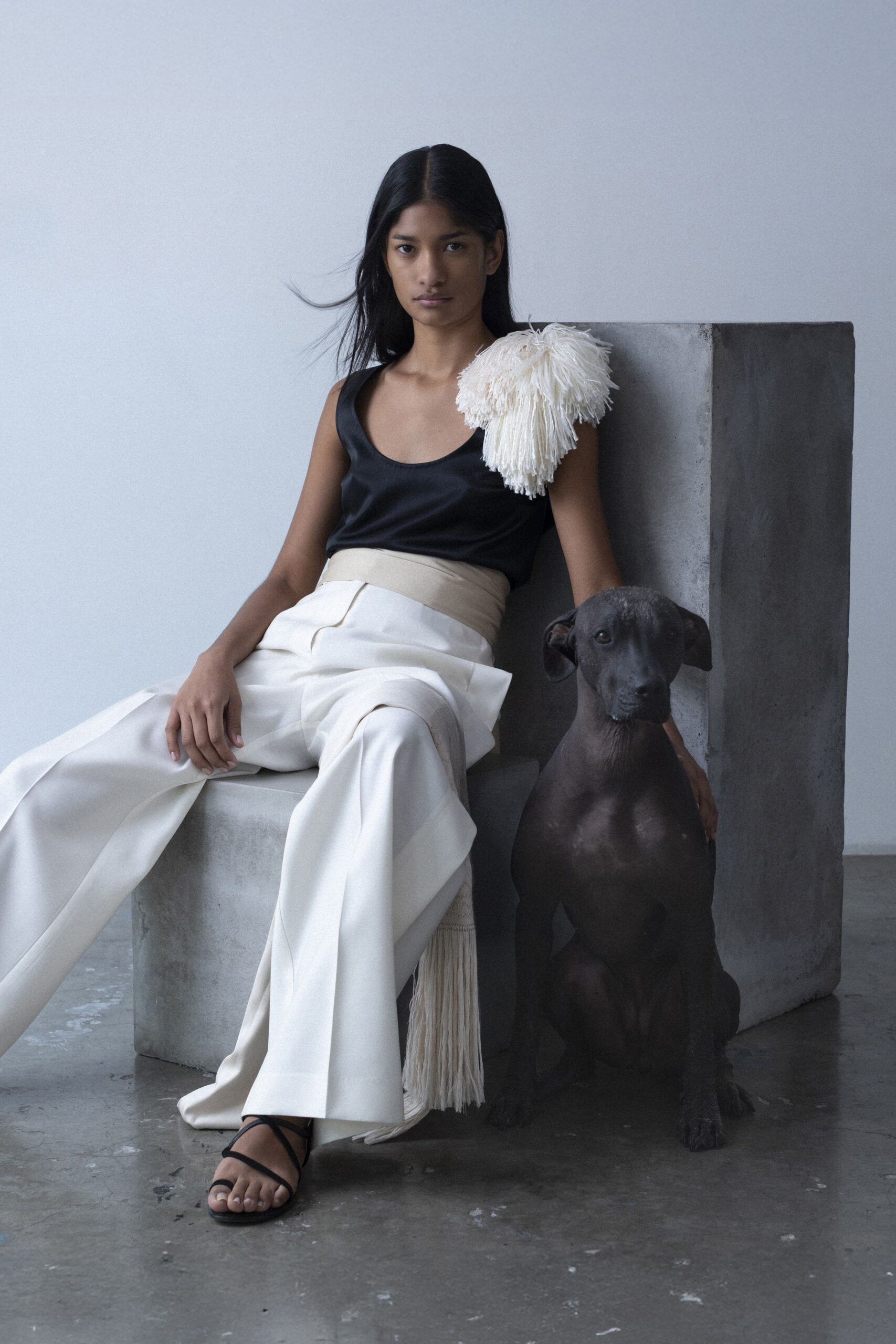black silk sleeveless top and white wide-leg pants