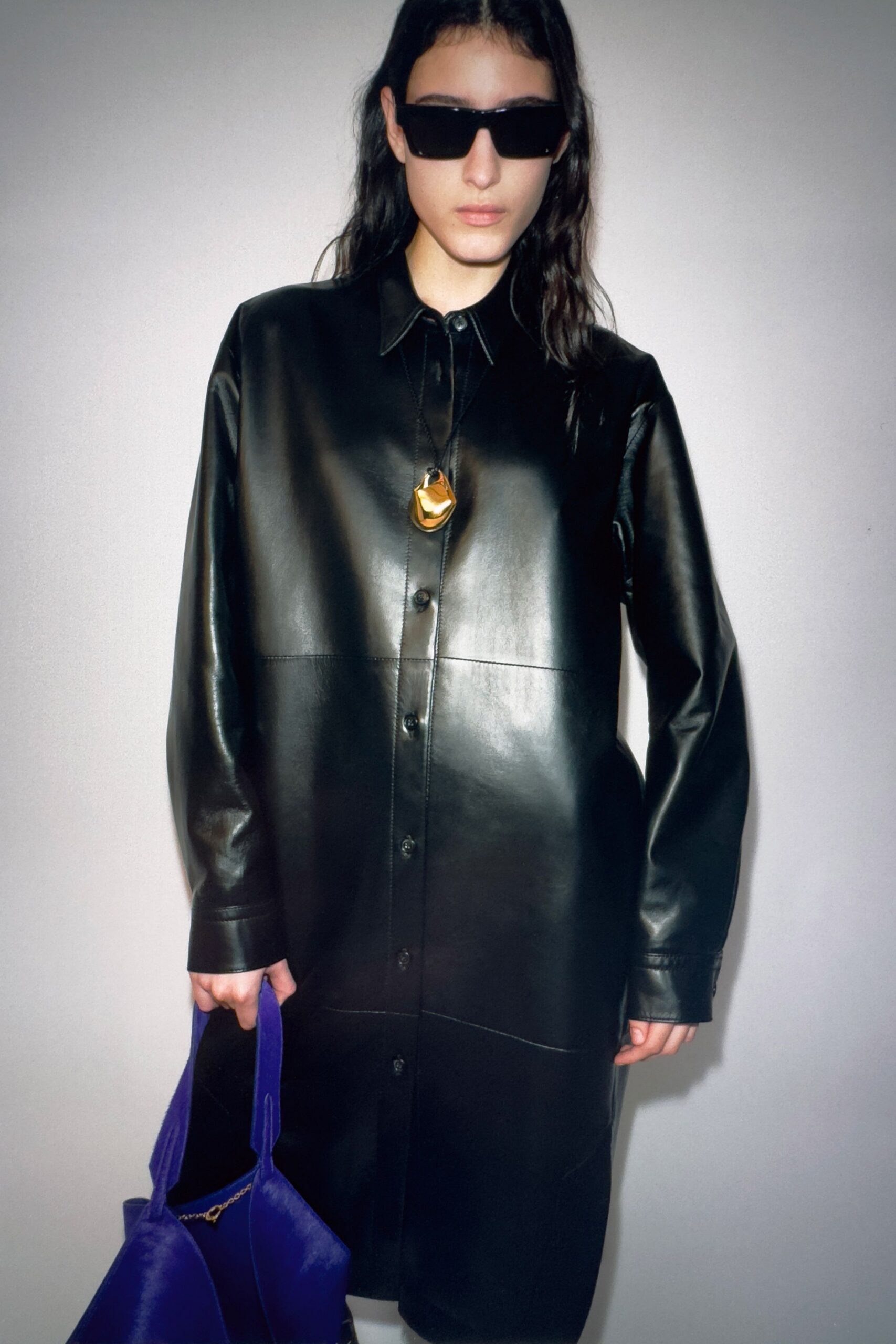 black leather shirt-dress with purple bag