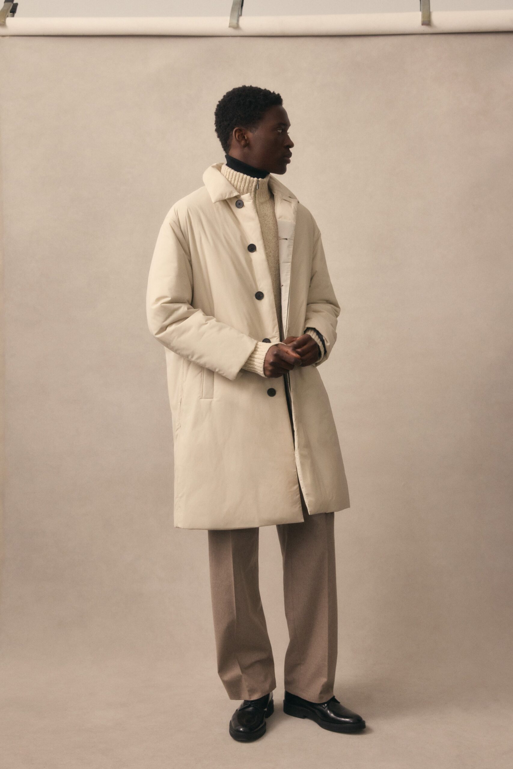 beige coat white sweater gray pants black shoes