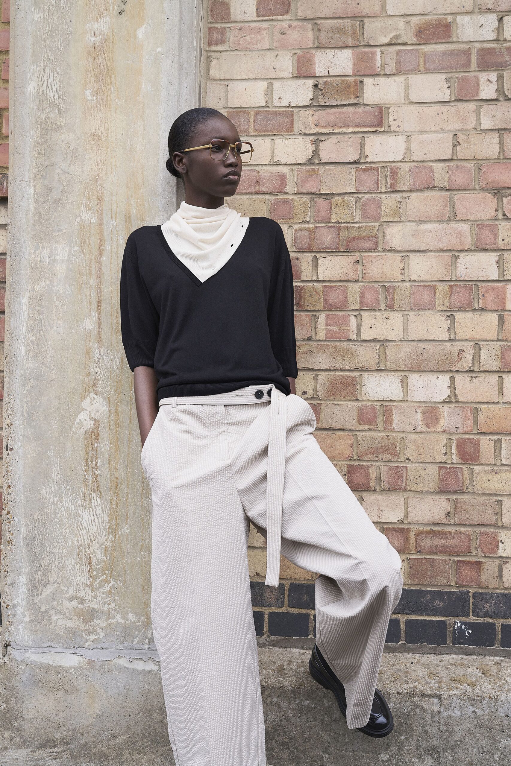 black relaxed top beige pleated pants