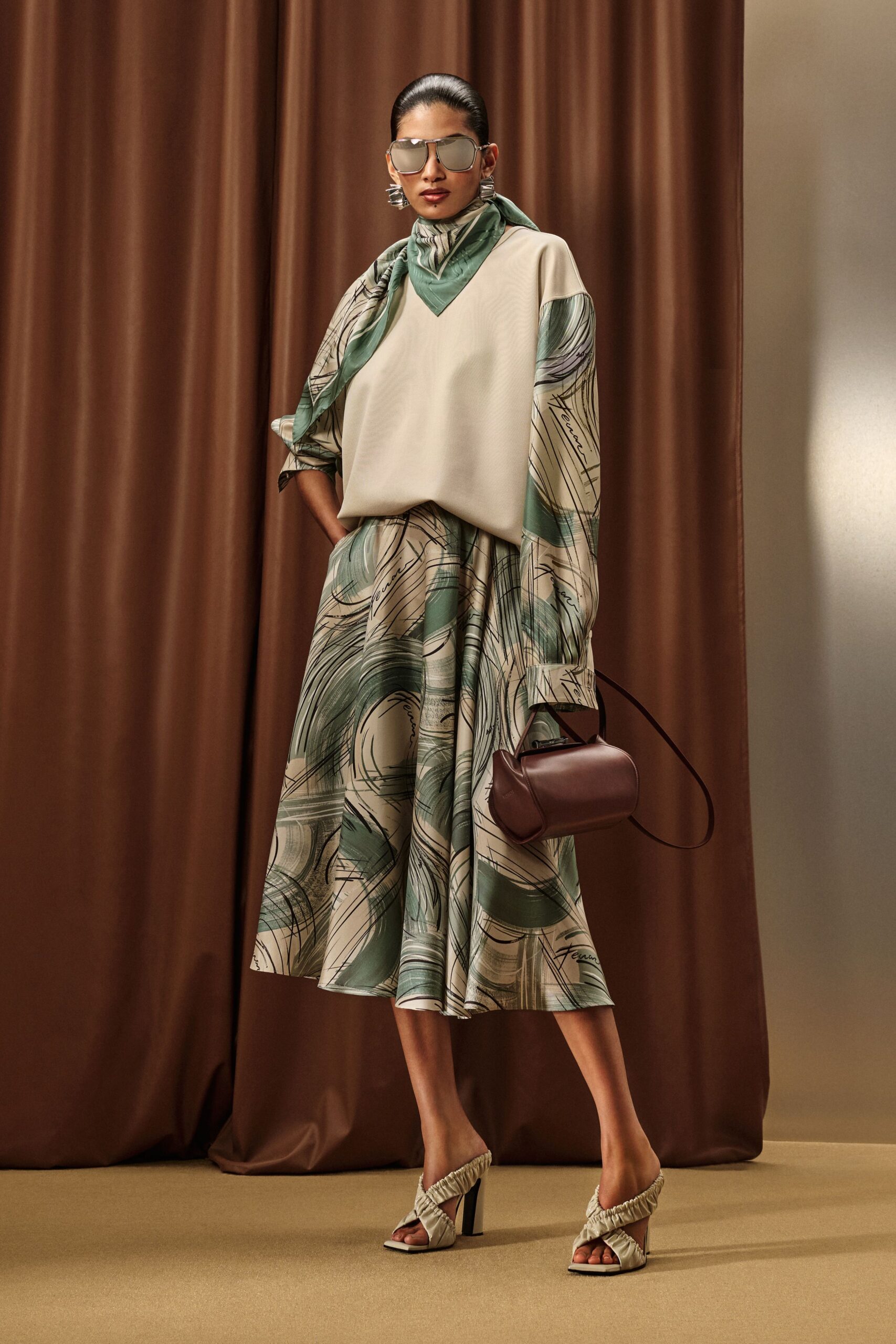 white relaxed top with green pleated skirt