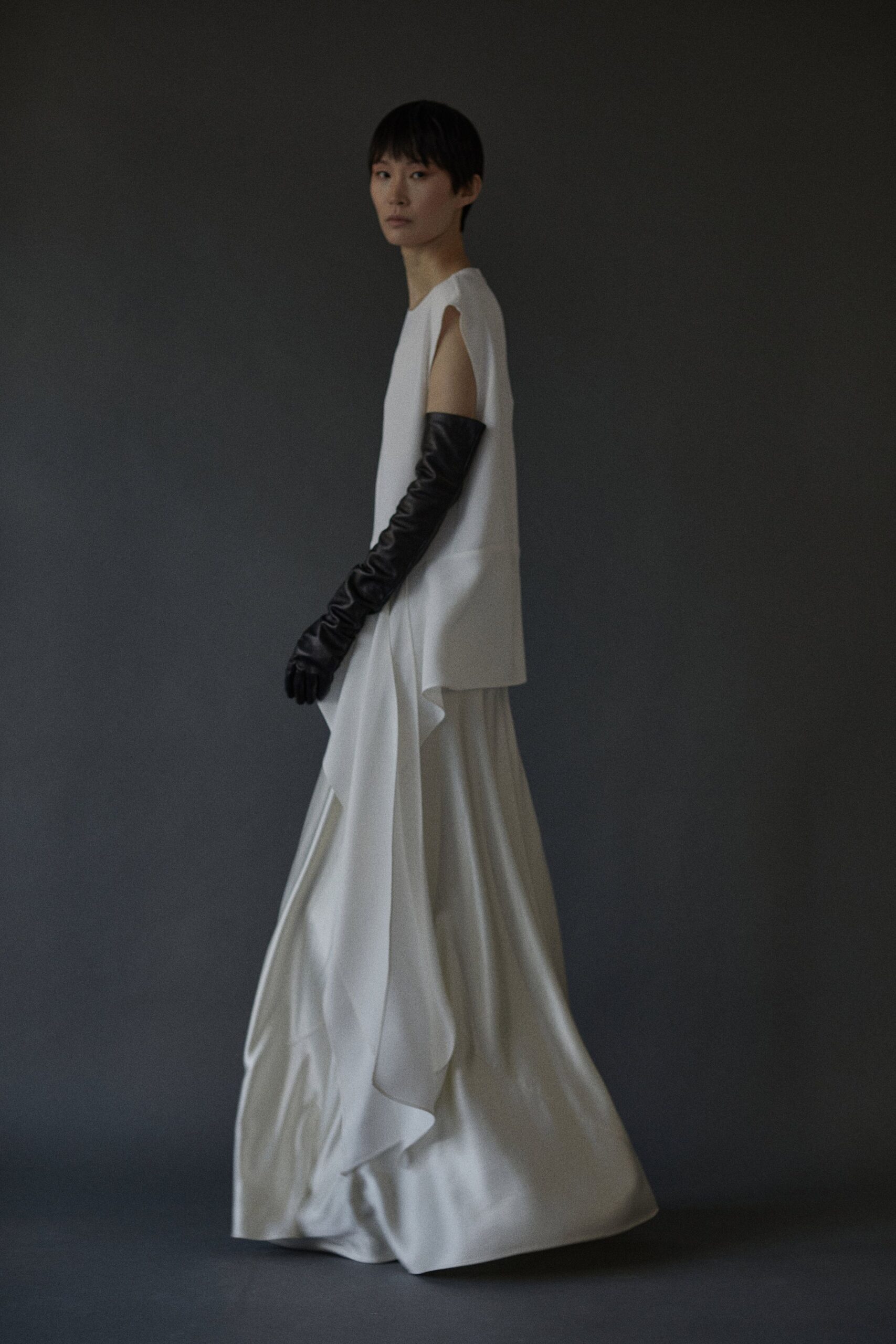 white silk draped maxi dress with black gloves