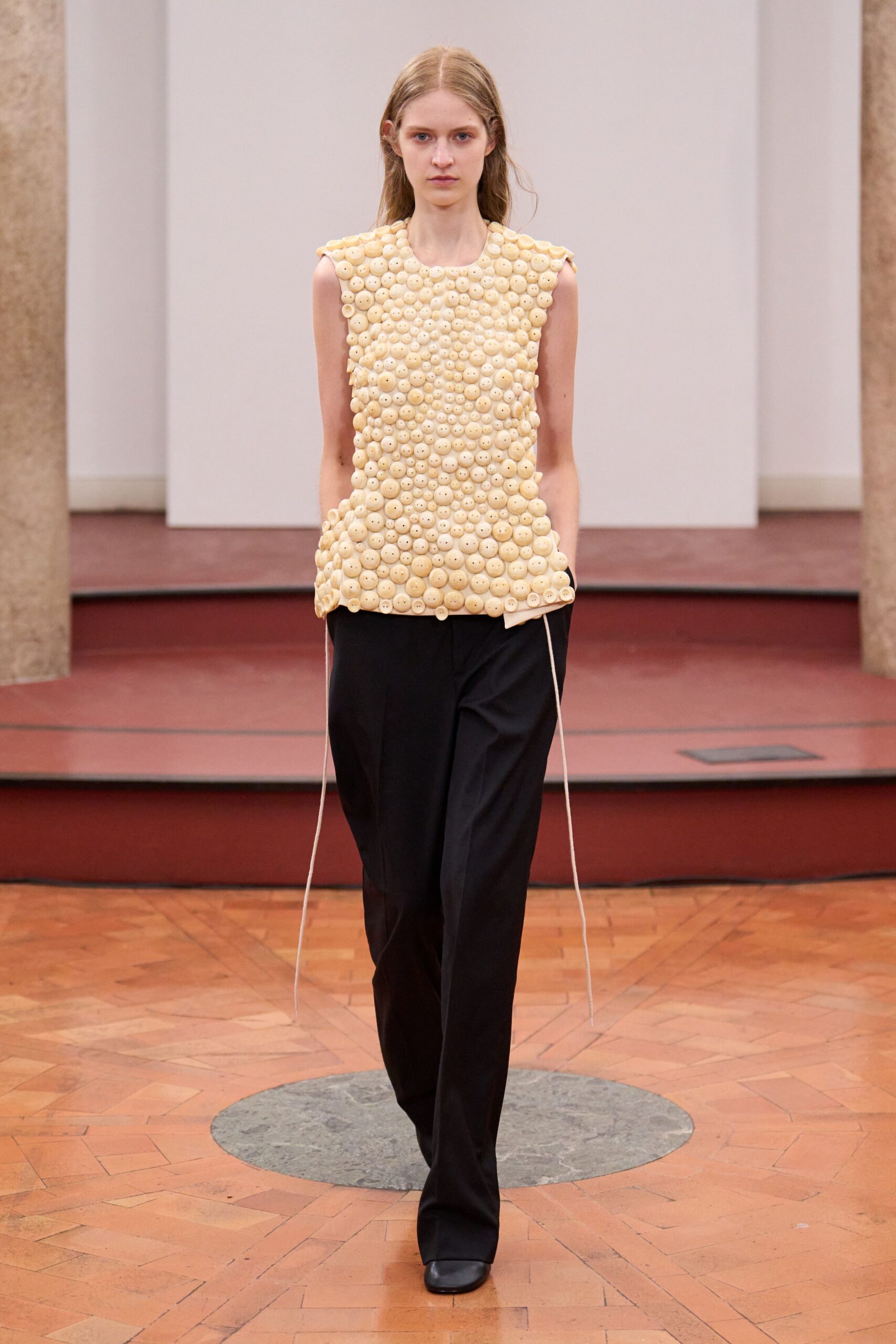 beige embellished top with black pants