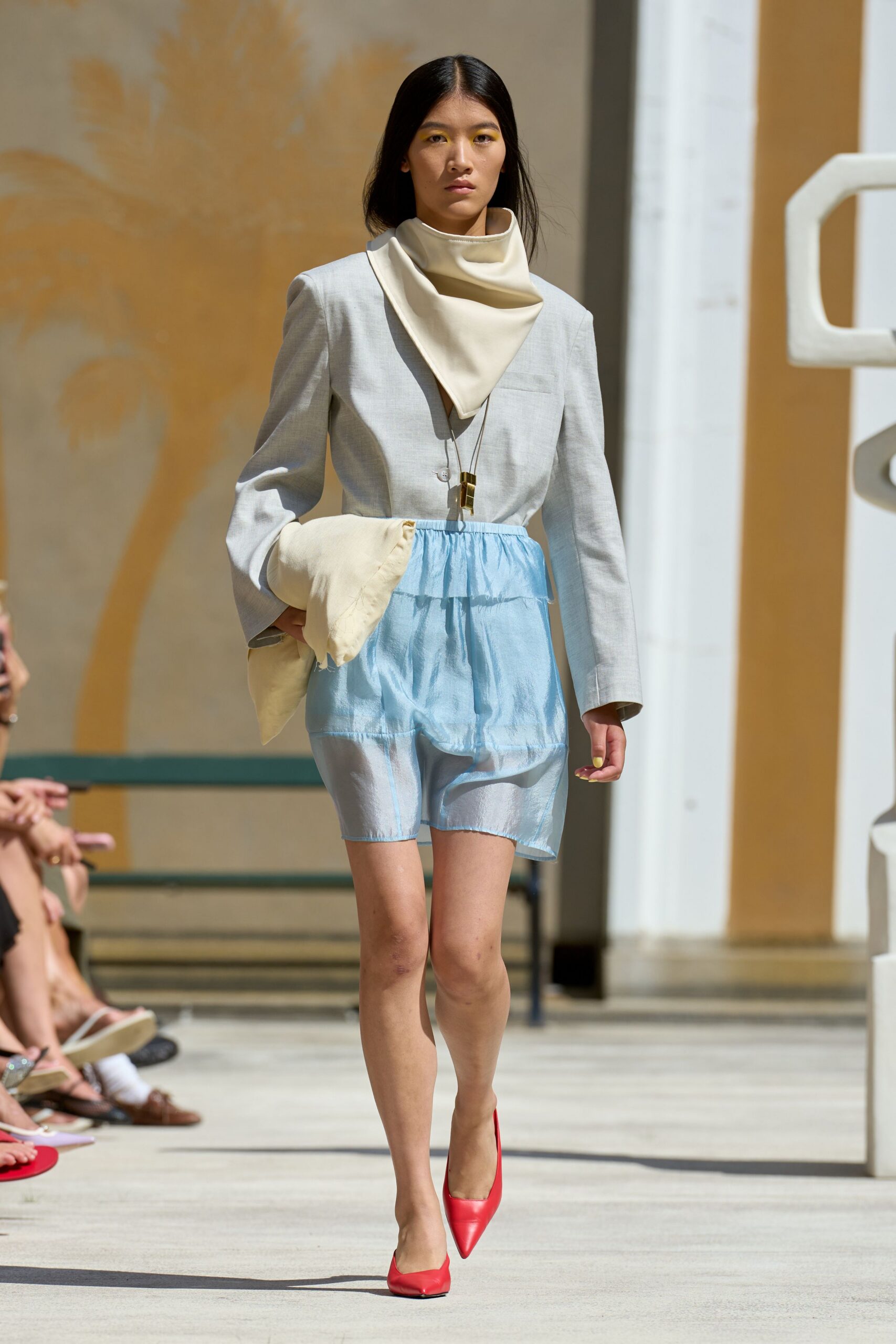 gray blazer beige top blue skirt red heels