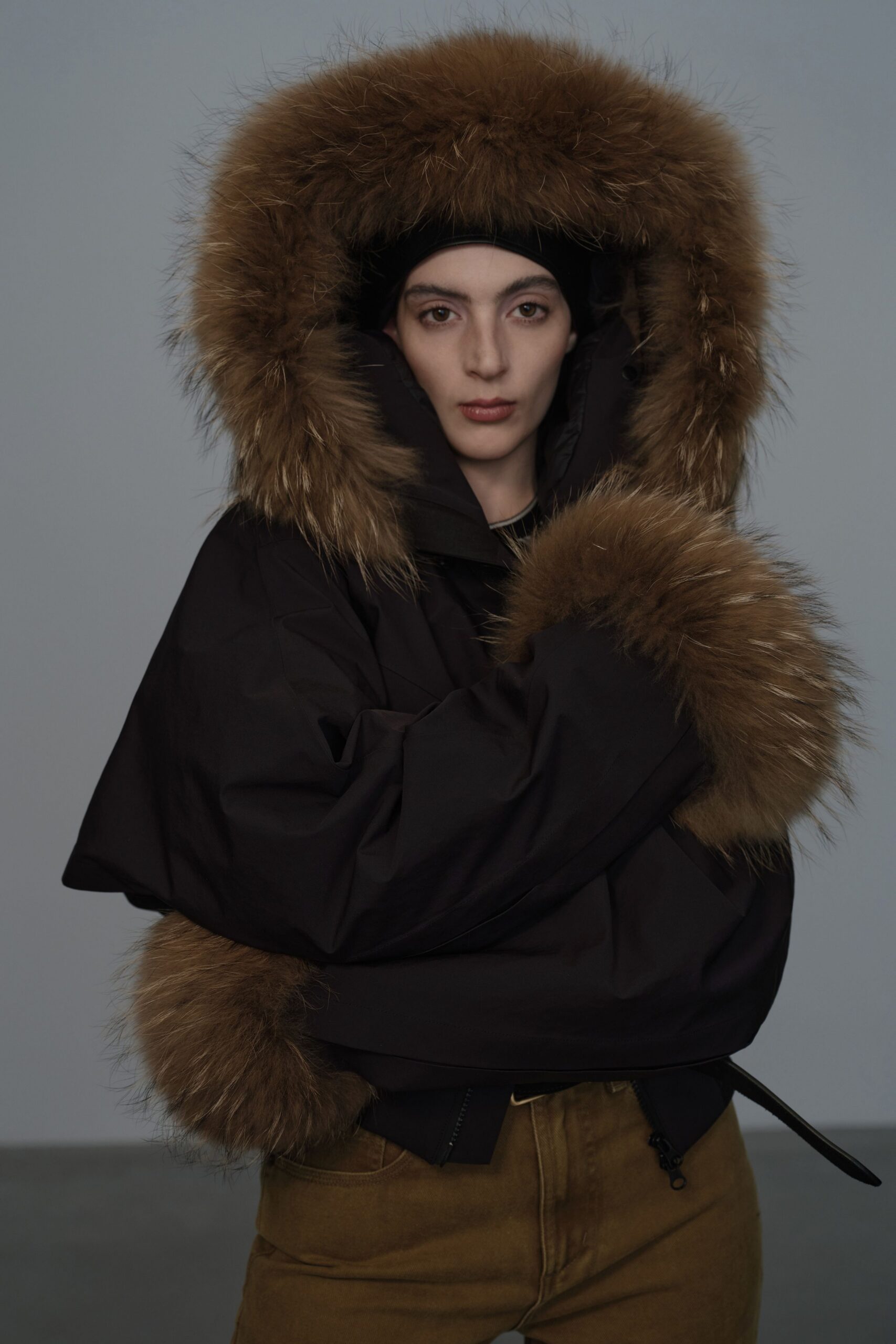 oversized black faux-fur jacket with brown pants