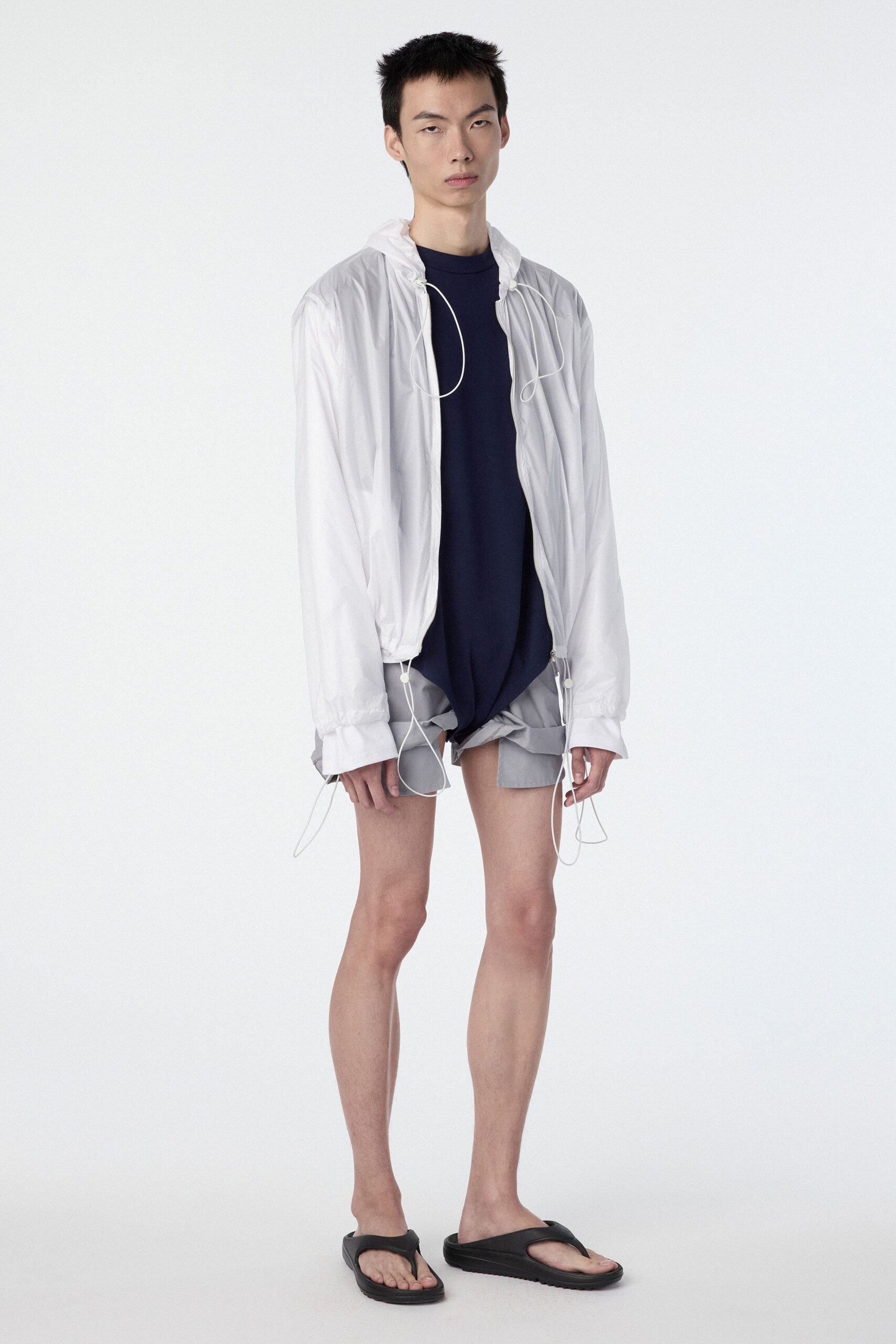 white jacket navy top gray shorts black sandals
