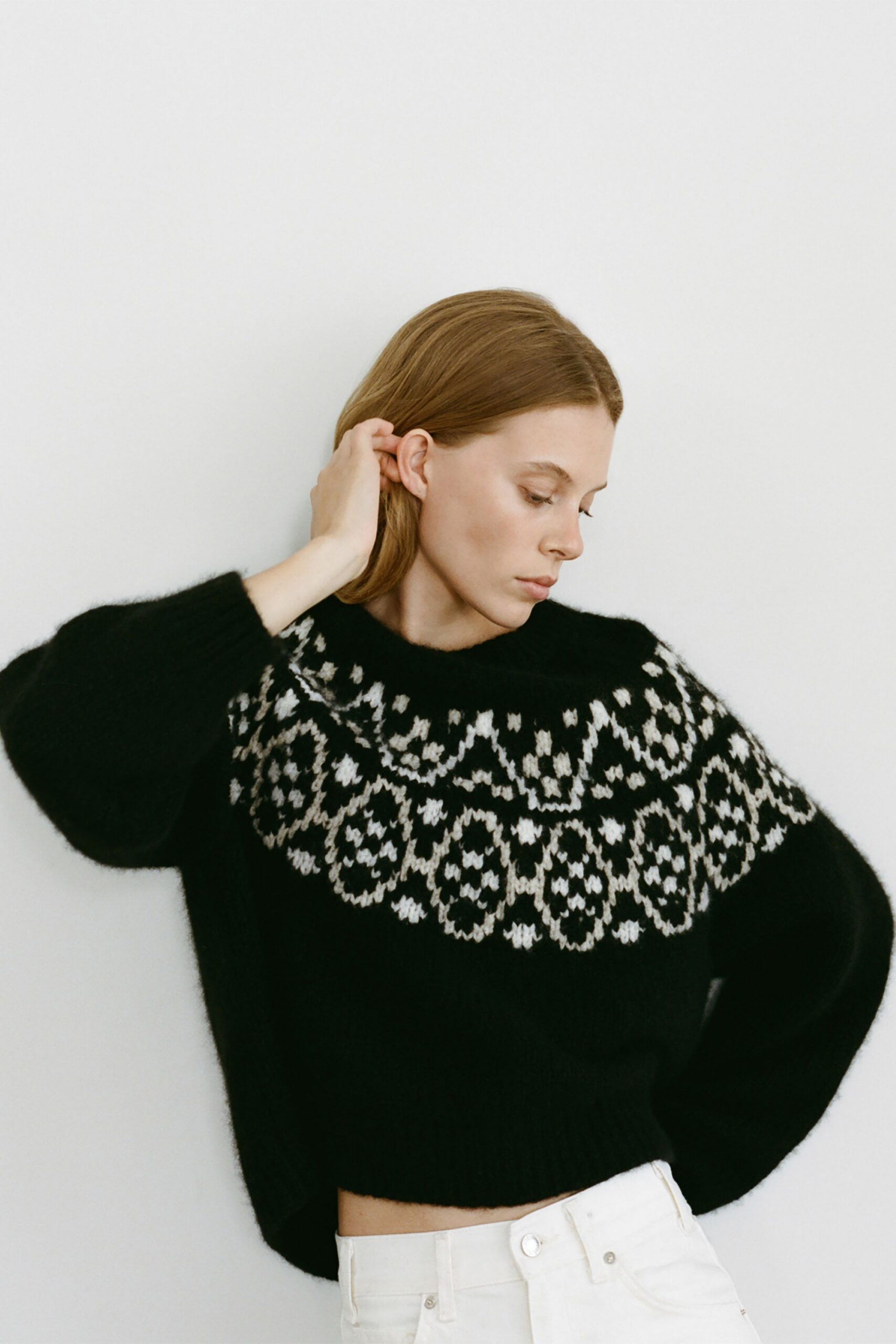 black and white embroidered sweater with white pants