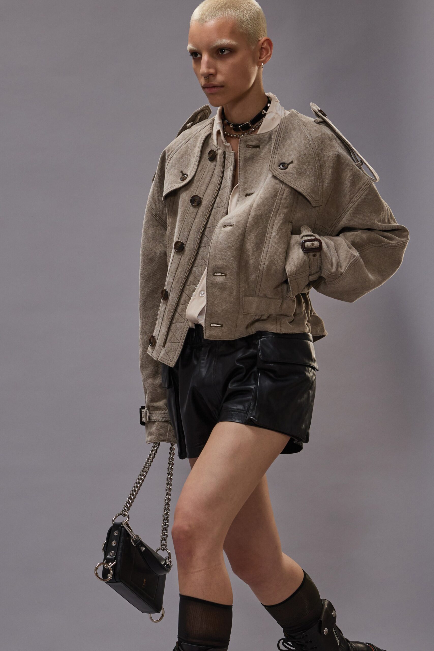 beige jacket black leather shorts