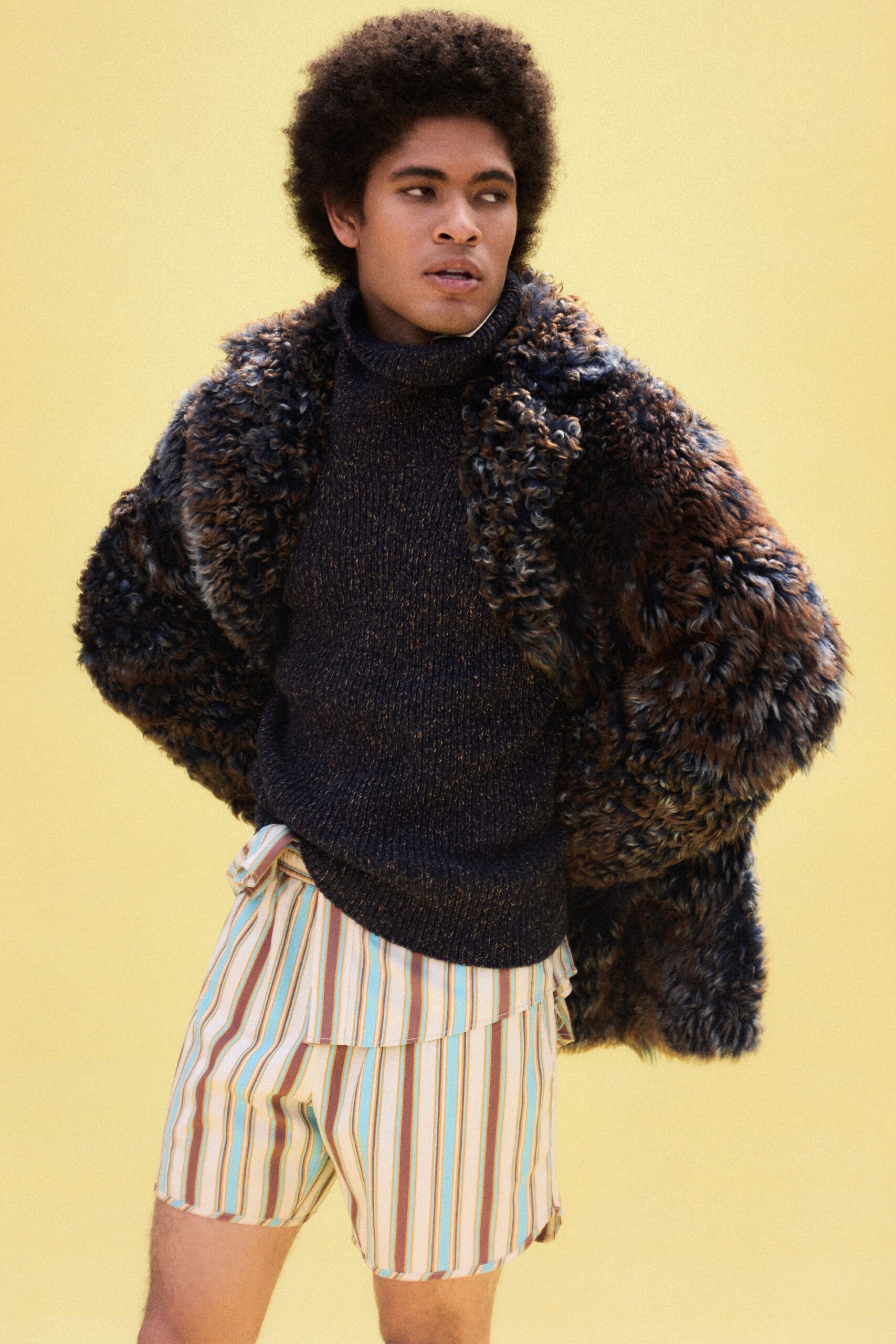 brown fur coat with black sweater and striped shorts