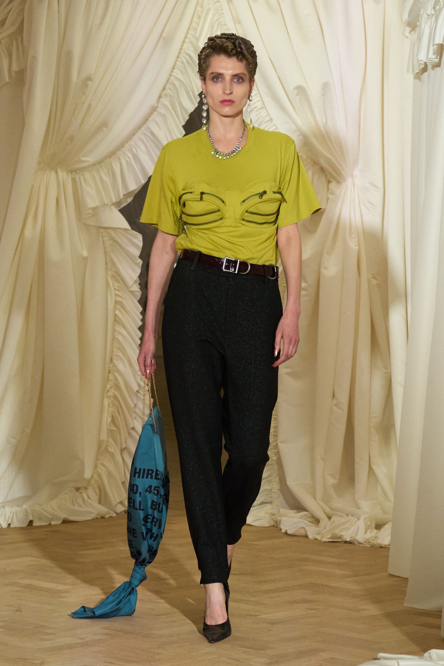 green fitted top with black pants