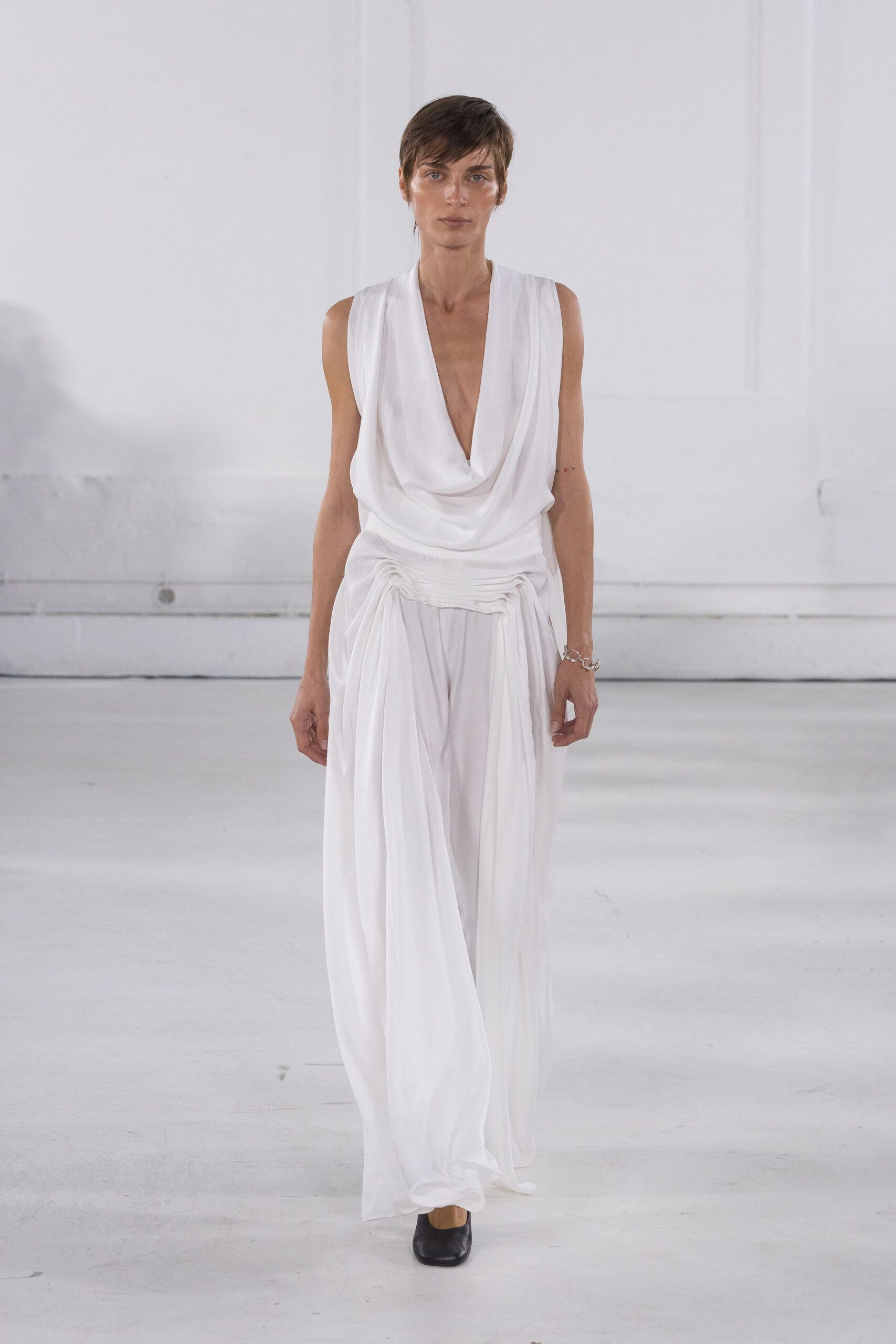 white silk draped gown with black shoes