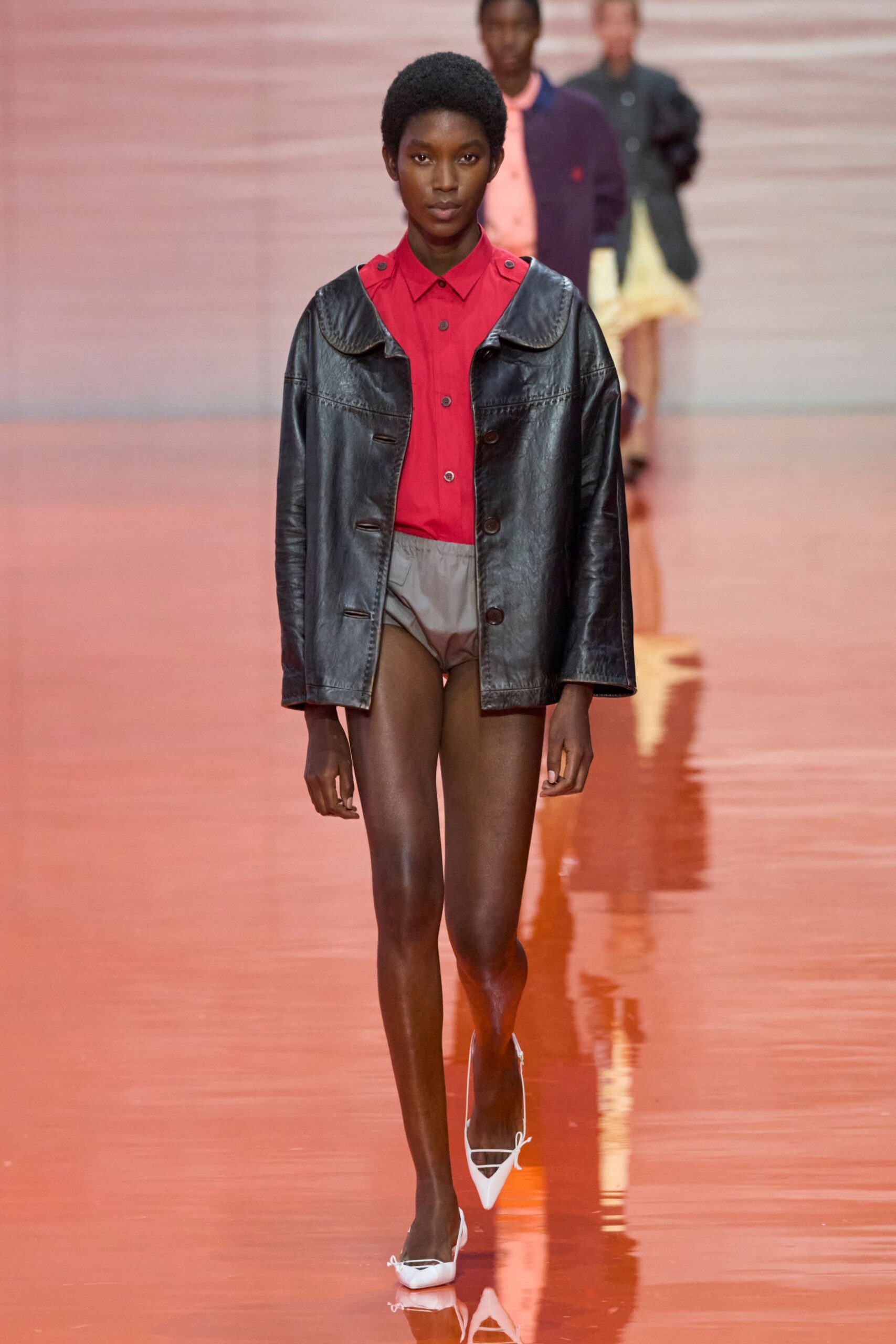 black leather jacket red shirt beige shorts