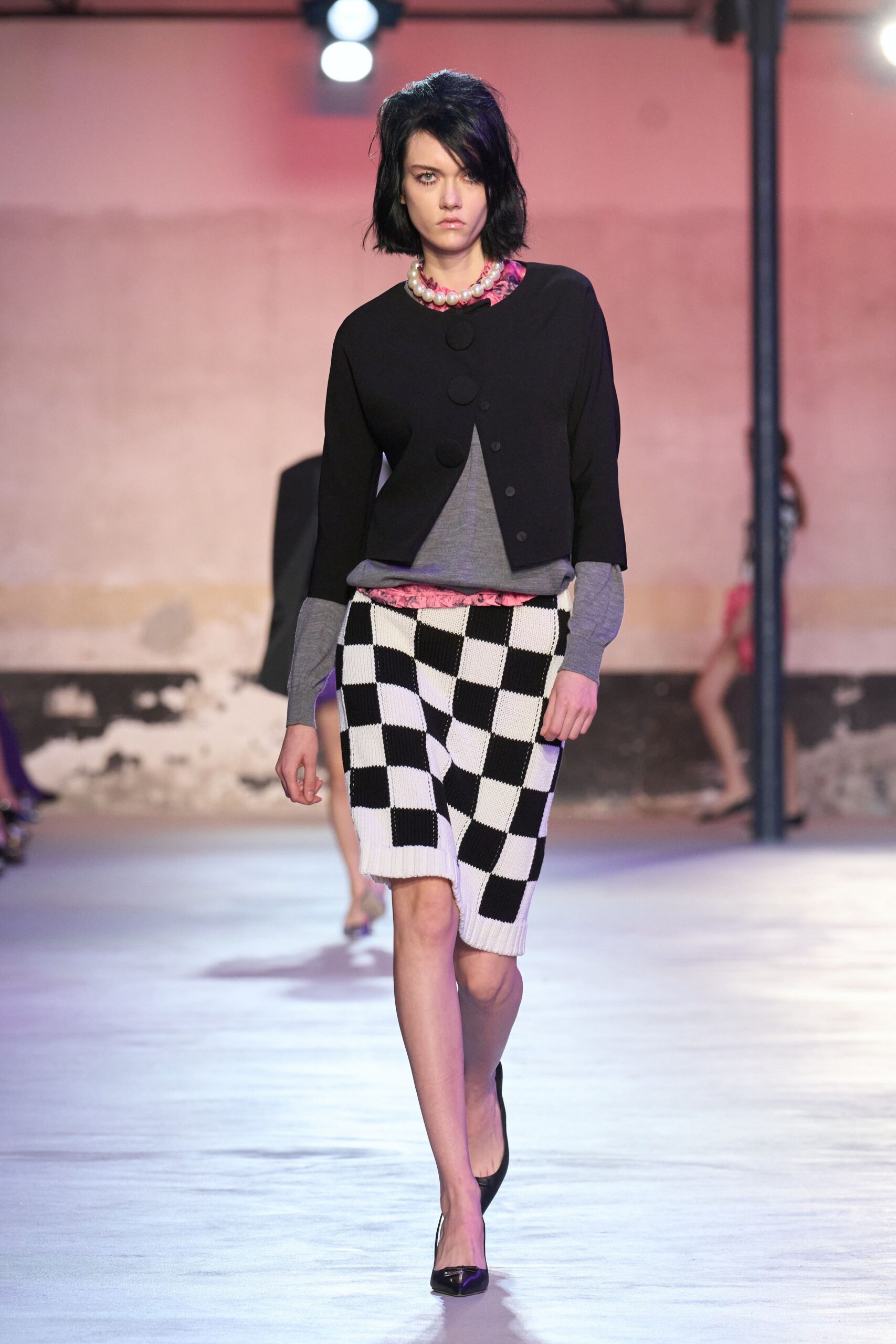 black jacket gray top checkered skirt
