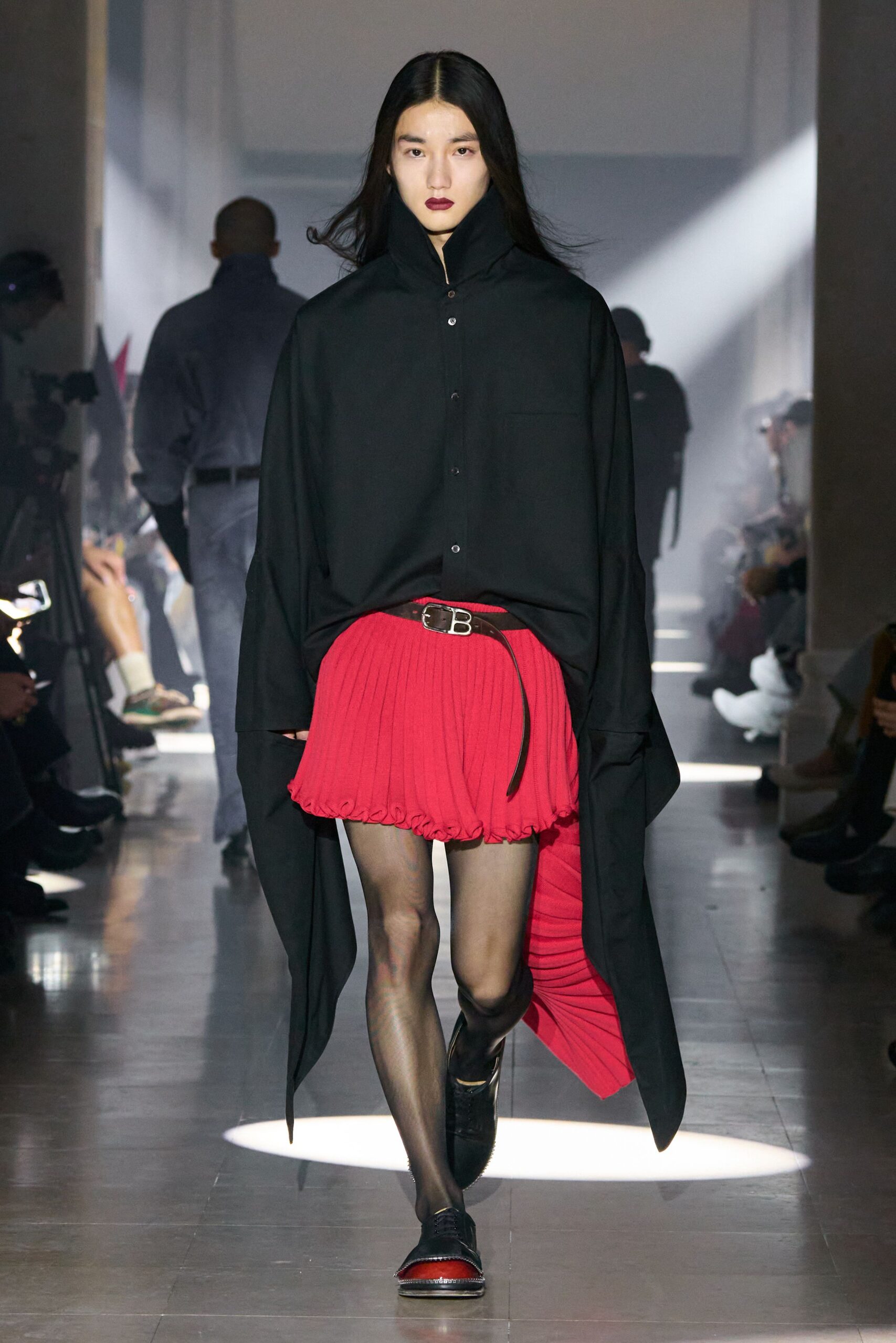 black oversized shirt with red pleated skirt