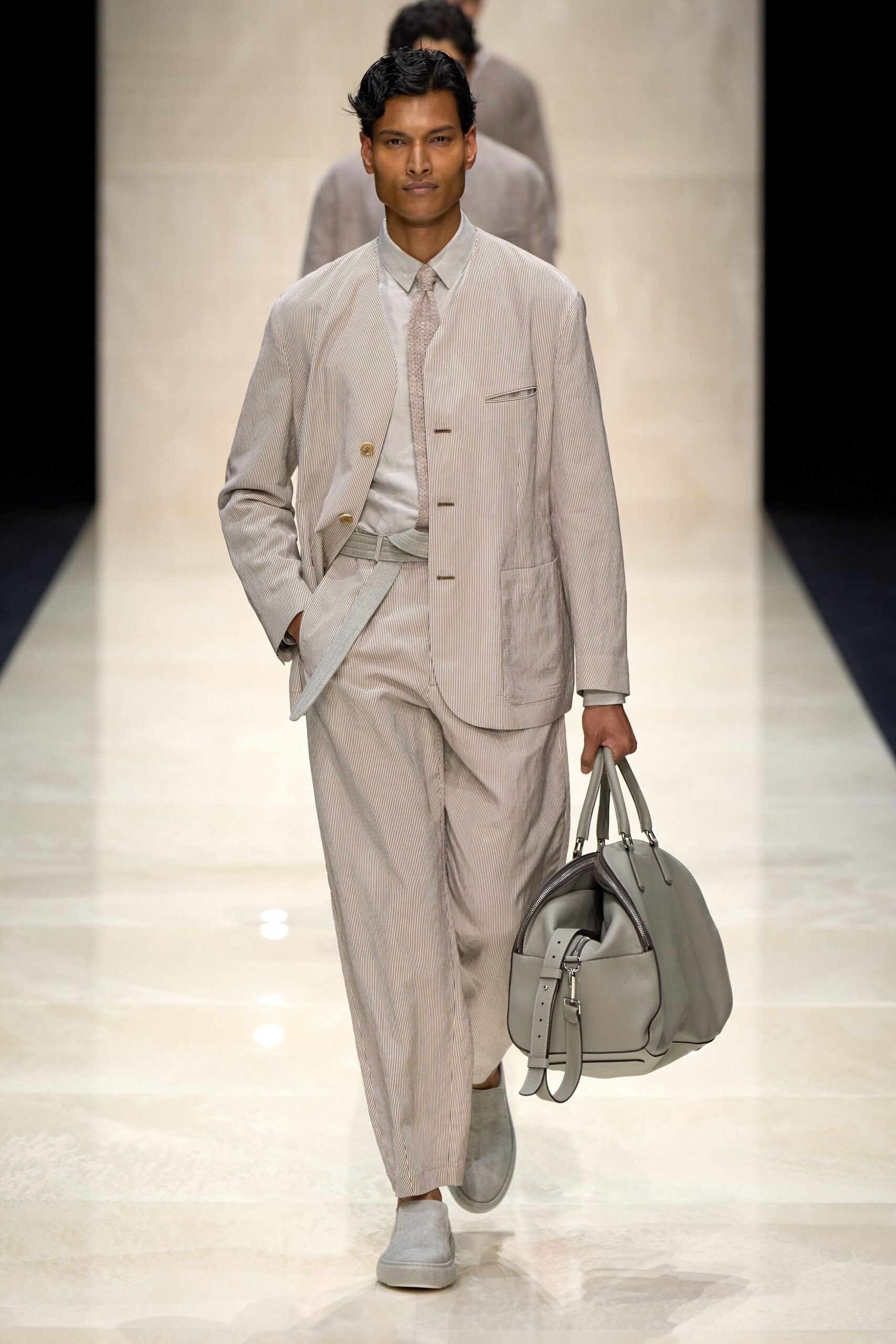 beige striped suit with gray bag
