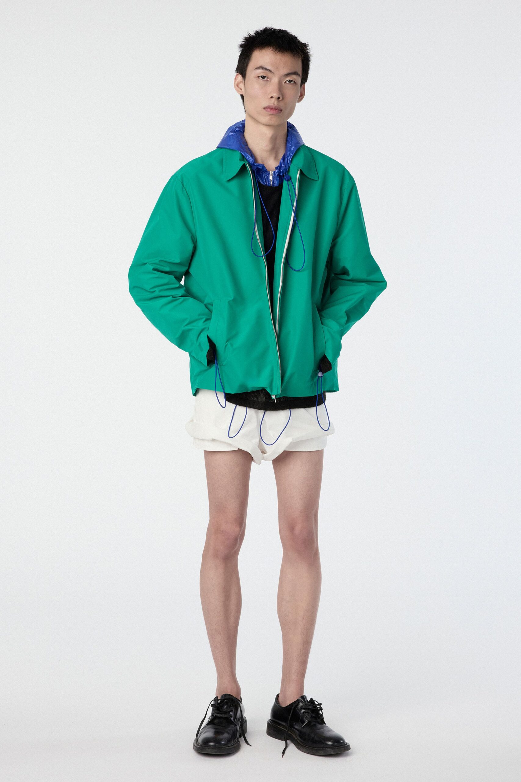 green jacket blue shirt white shorts