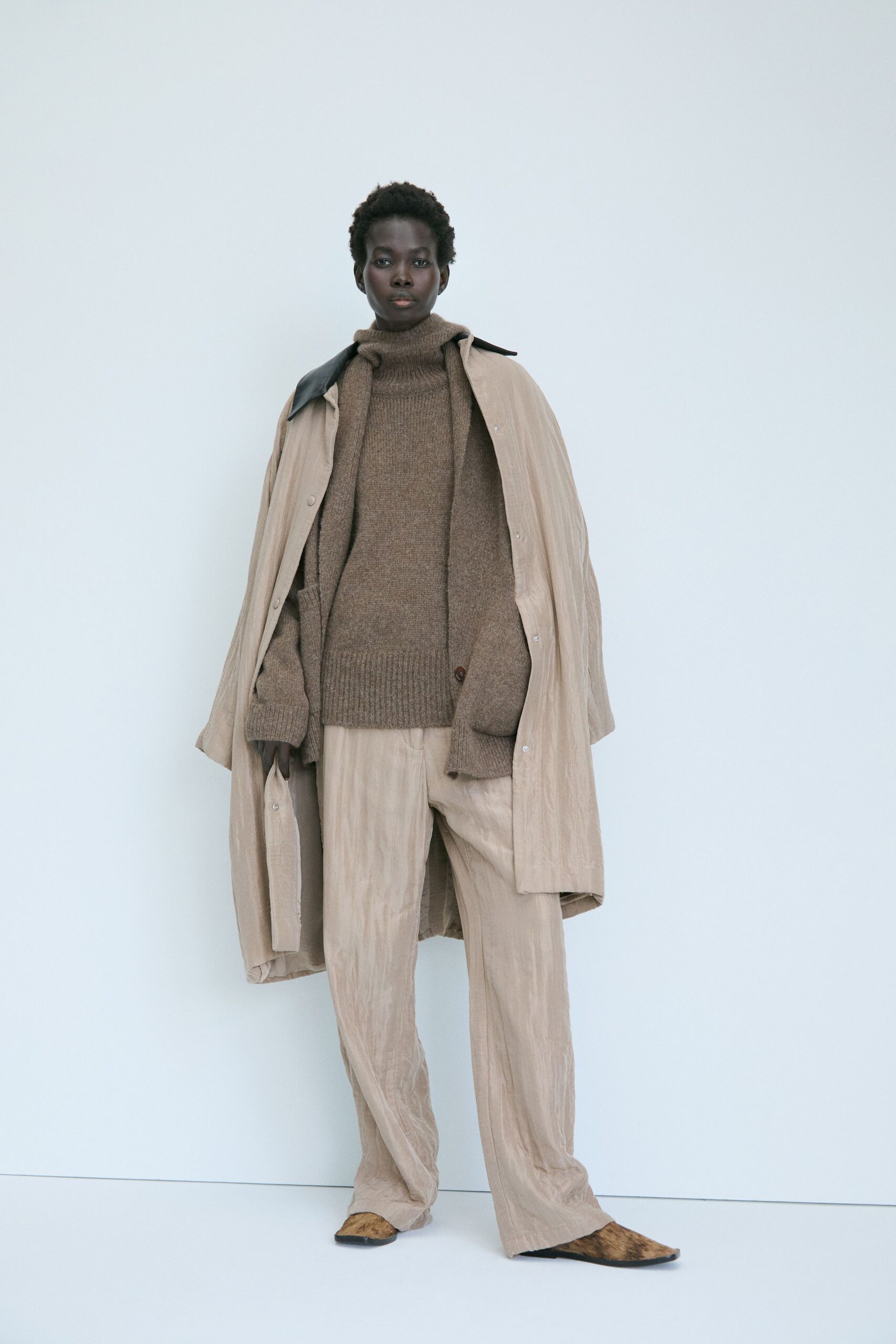 beige coat brown sweater relaxed pants