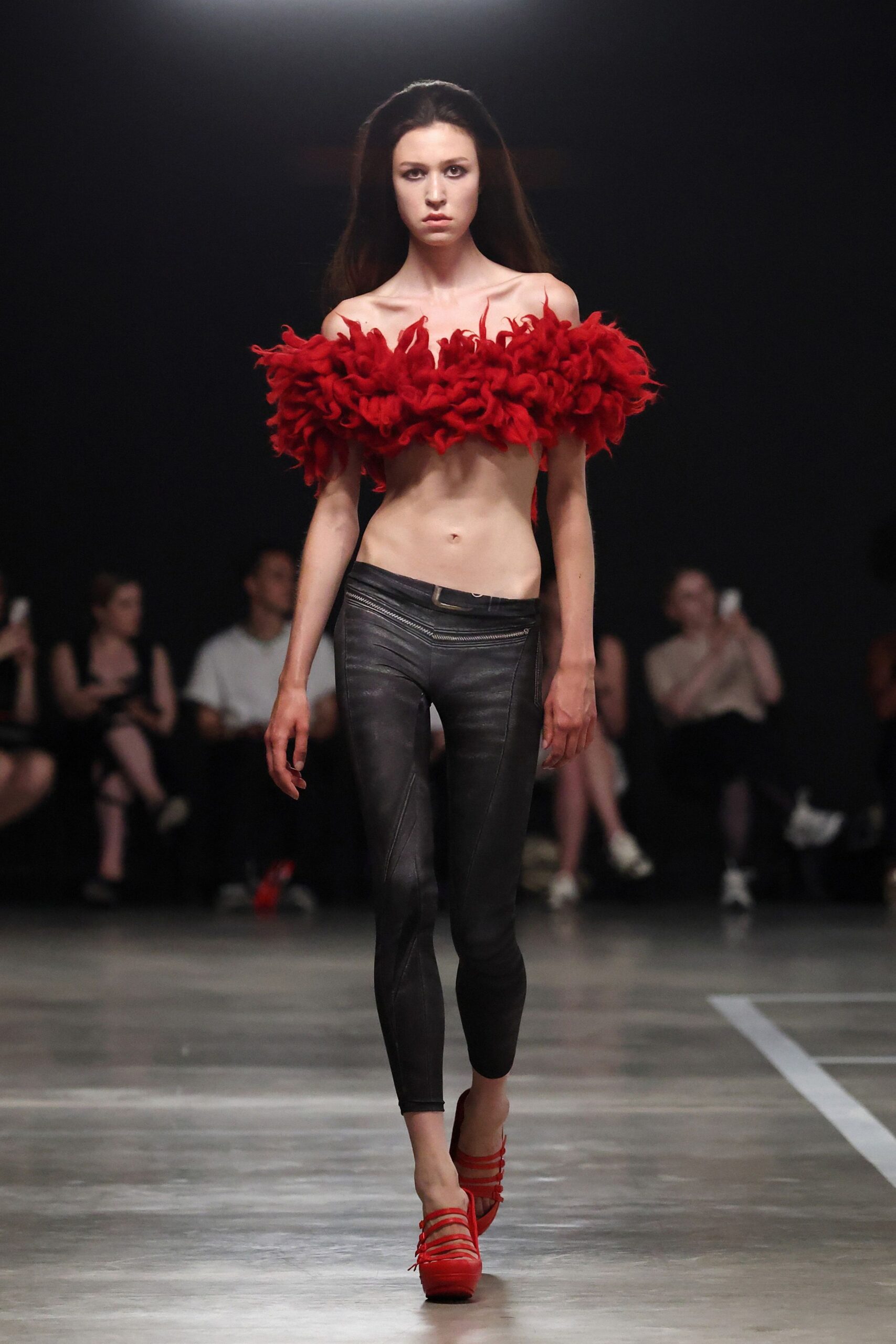 red ruffled top with black pants