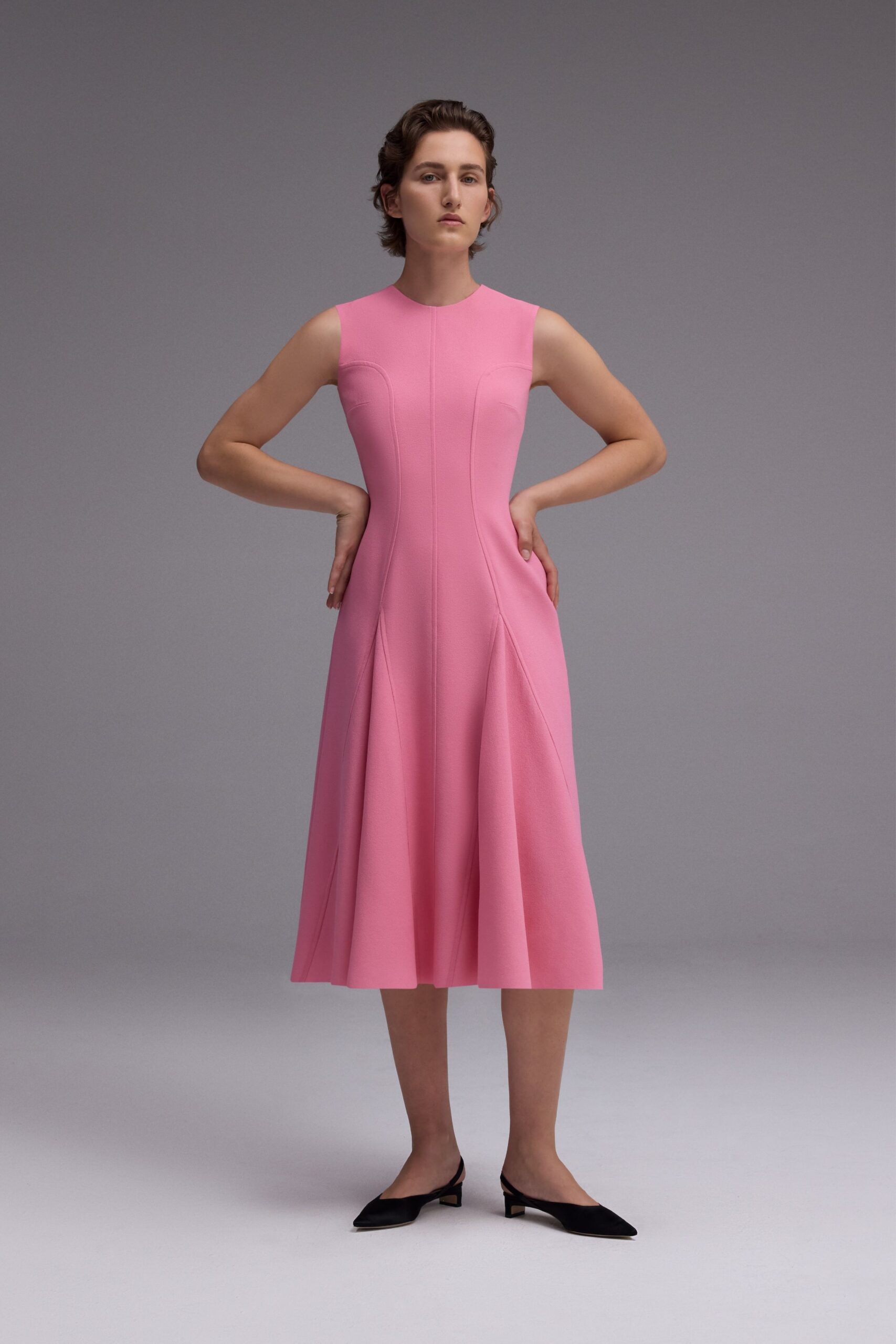pink fitted midi dress with black shoes
