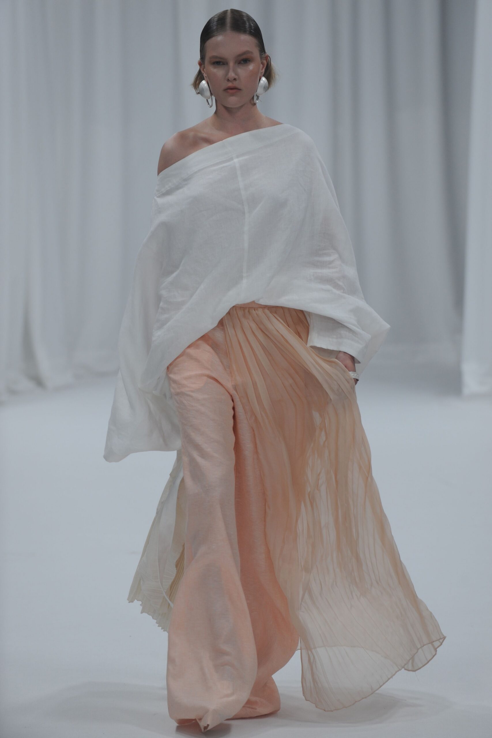 white off-shoulder top and peach pleated pants