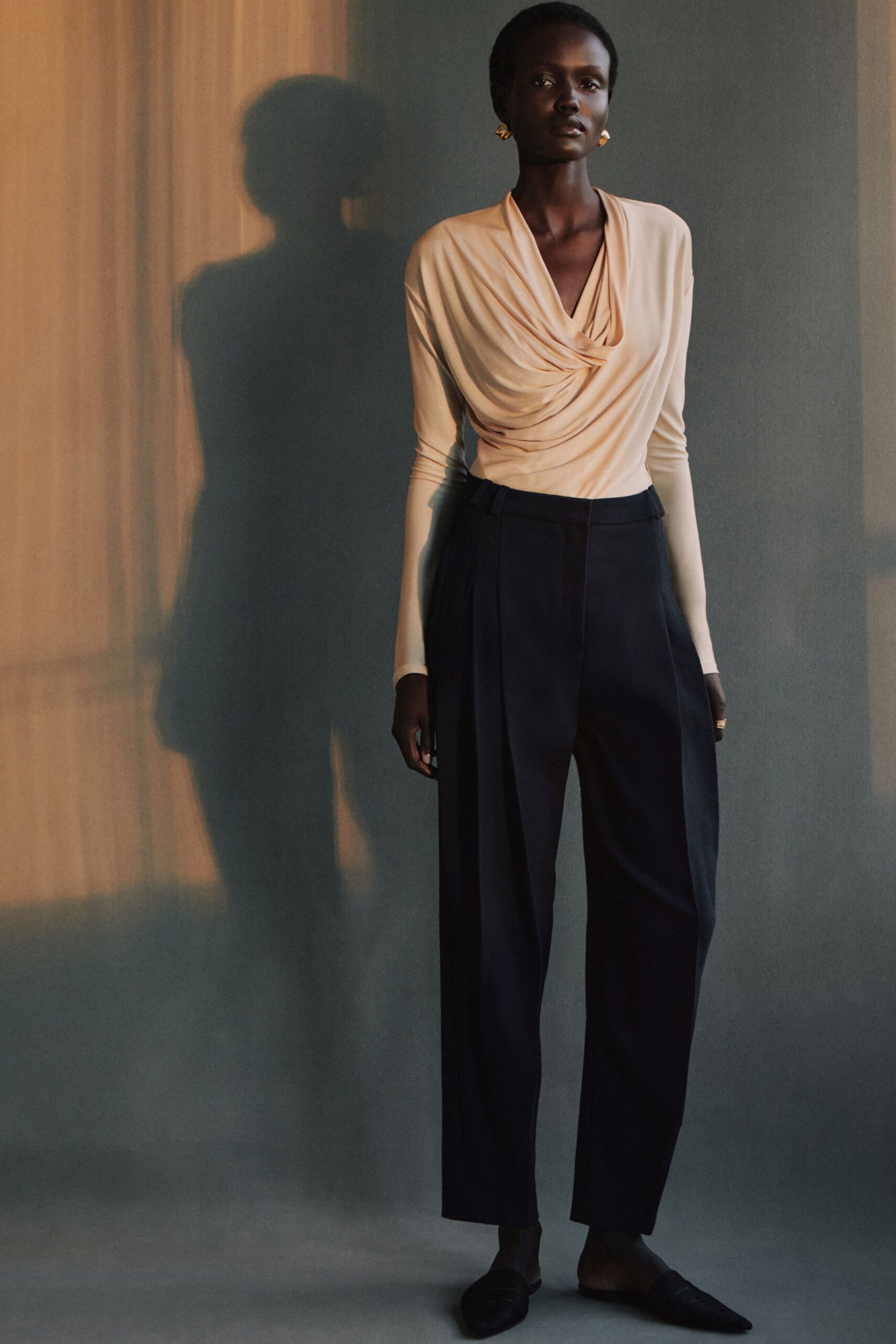 beige silk draped top with black pants