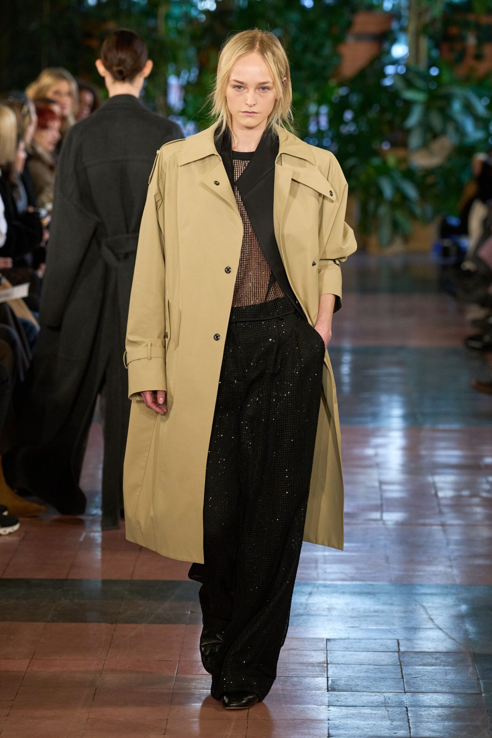 beige trench coat with black top and pants