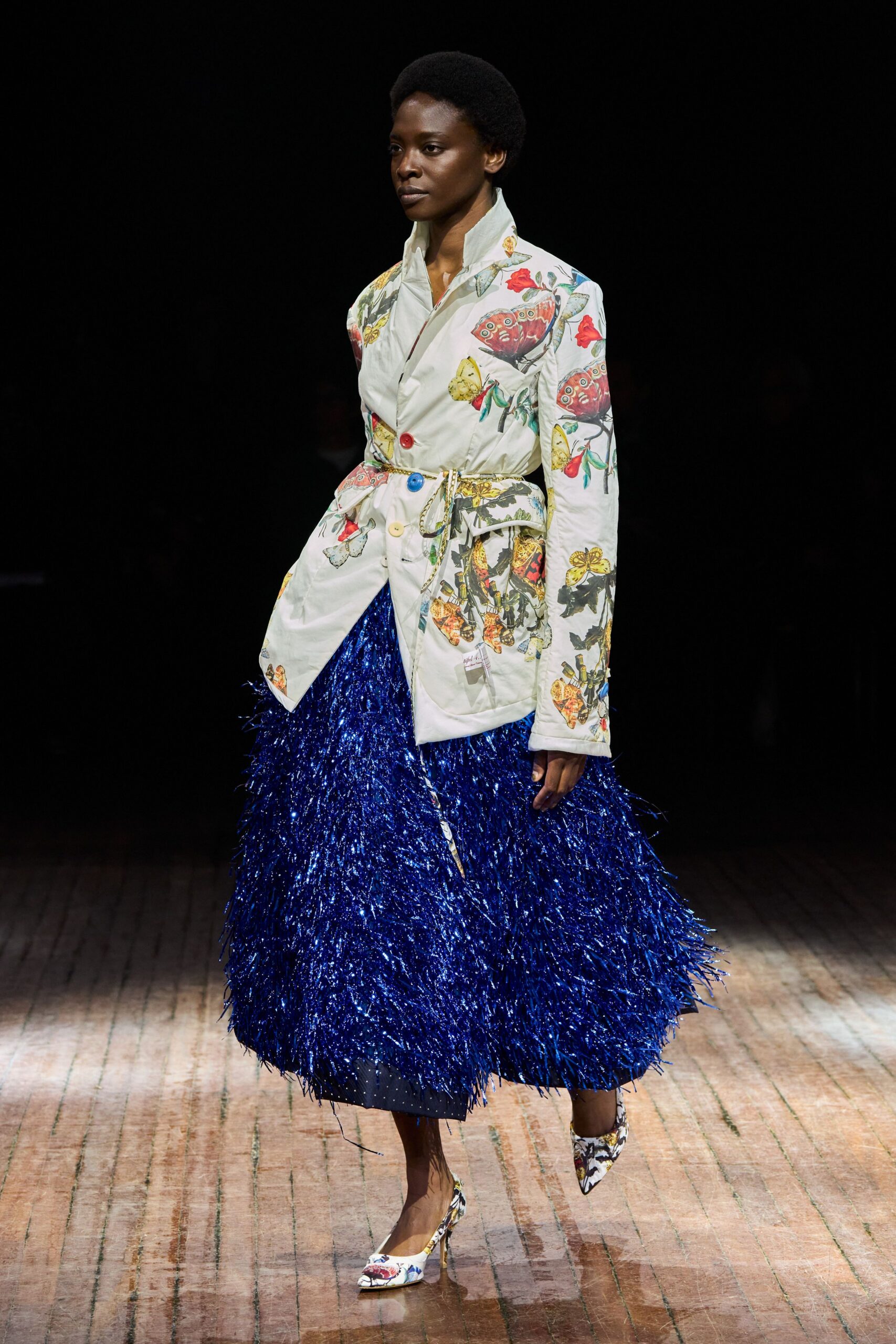 embroidered white jacket with fringed blue skirt