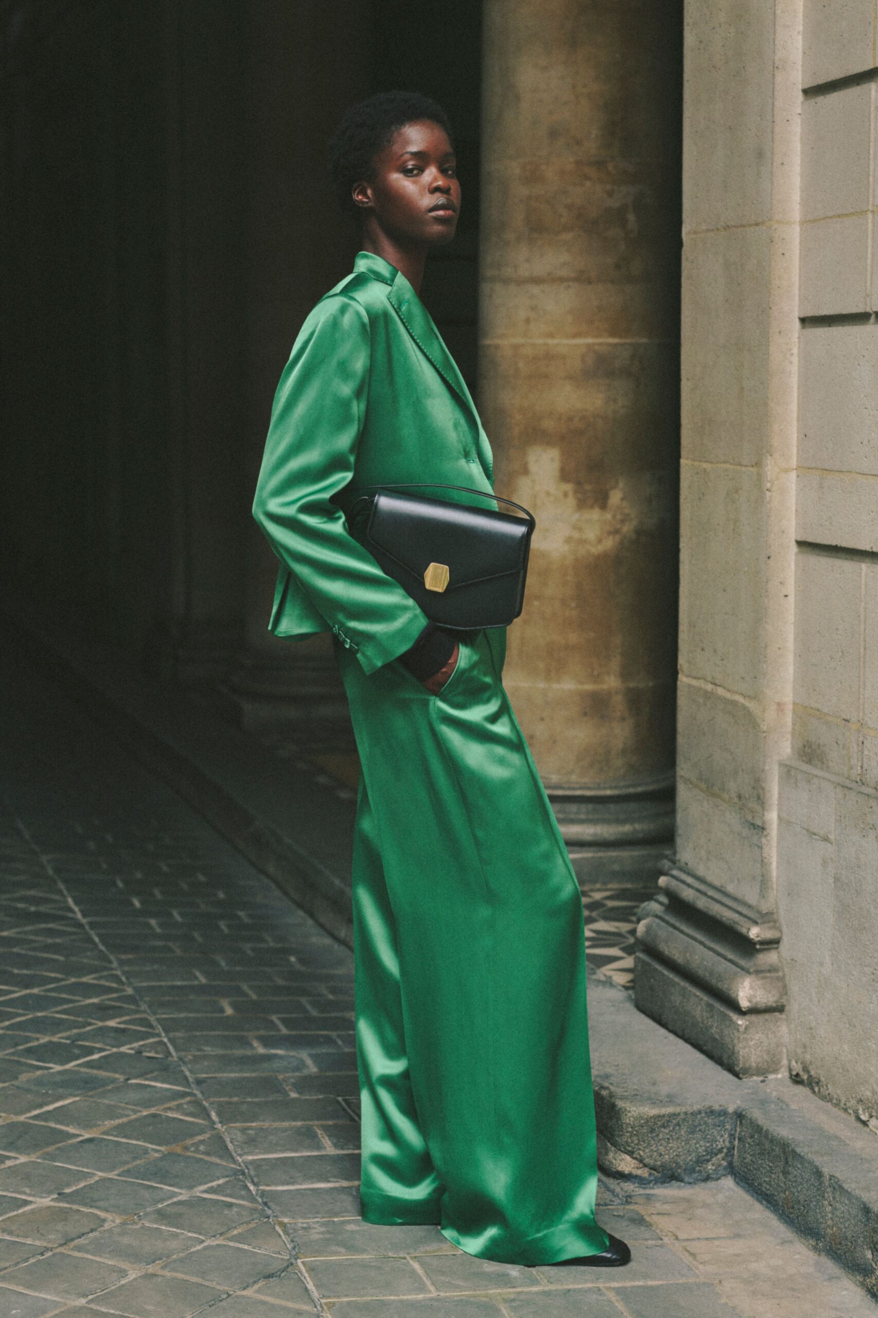 green silk fitted suit with black bag