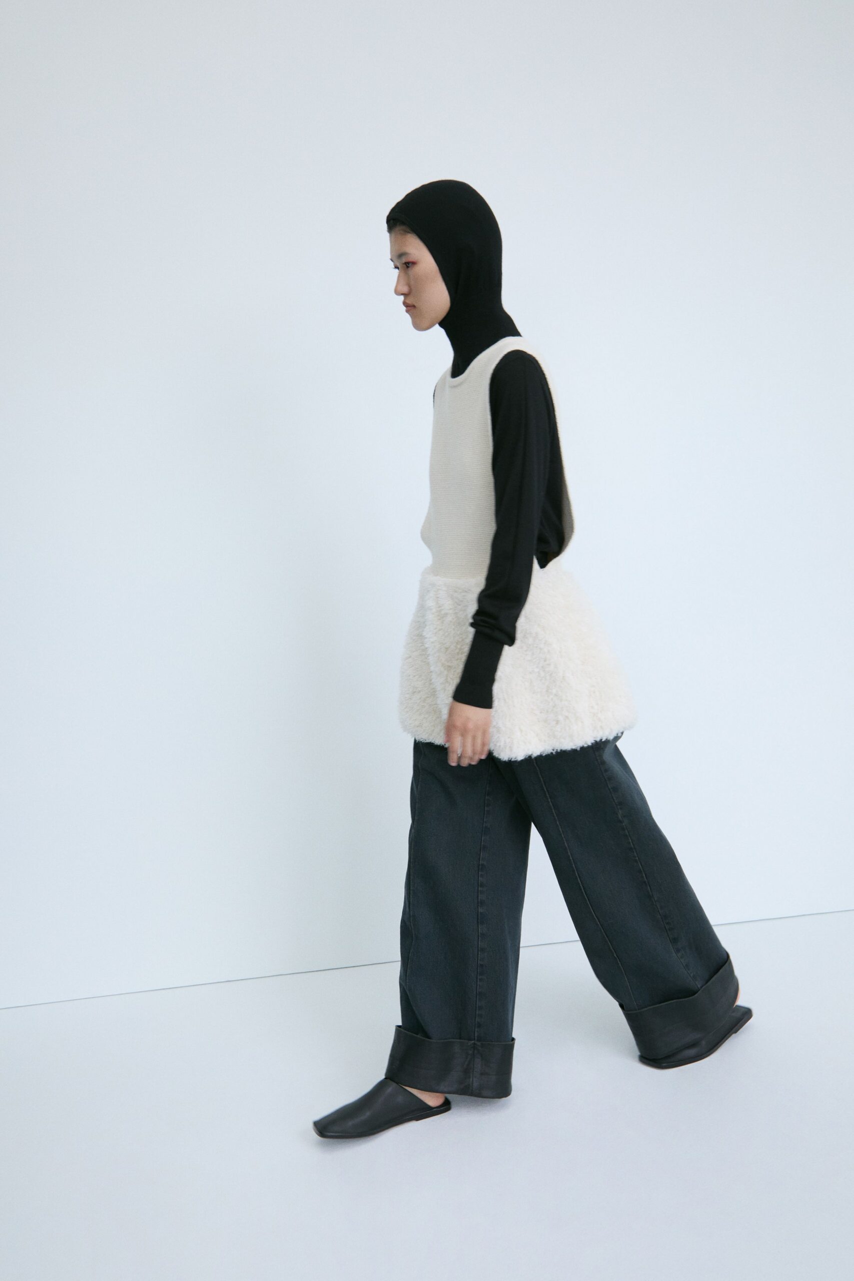 black fitted turtleneck top with white faux-fur vest