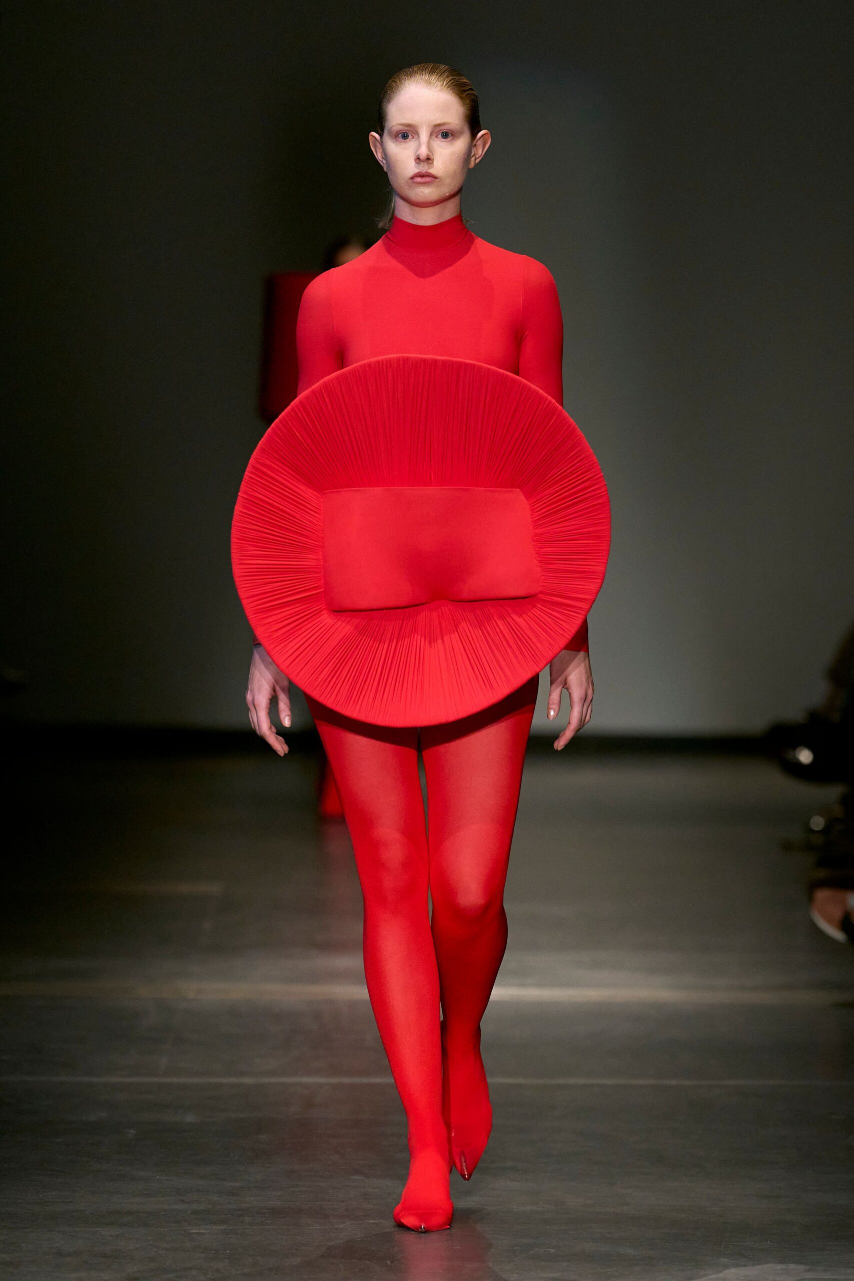 red fitted catsuit with pleated accessory