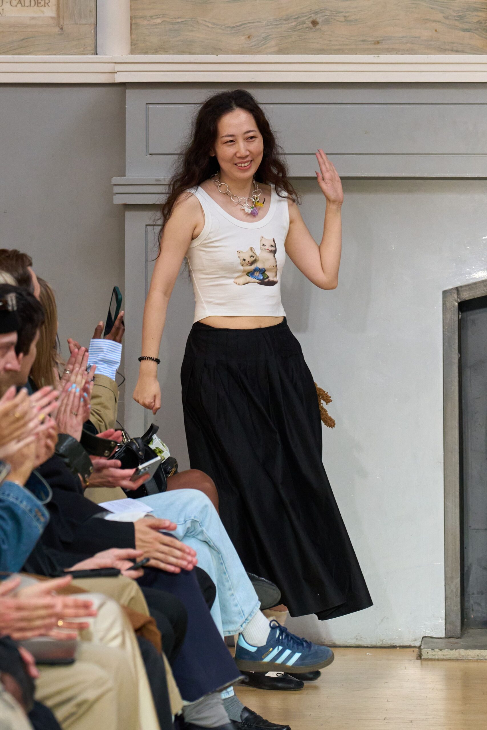 white printed sleeveless top and black pleated skirt