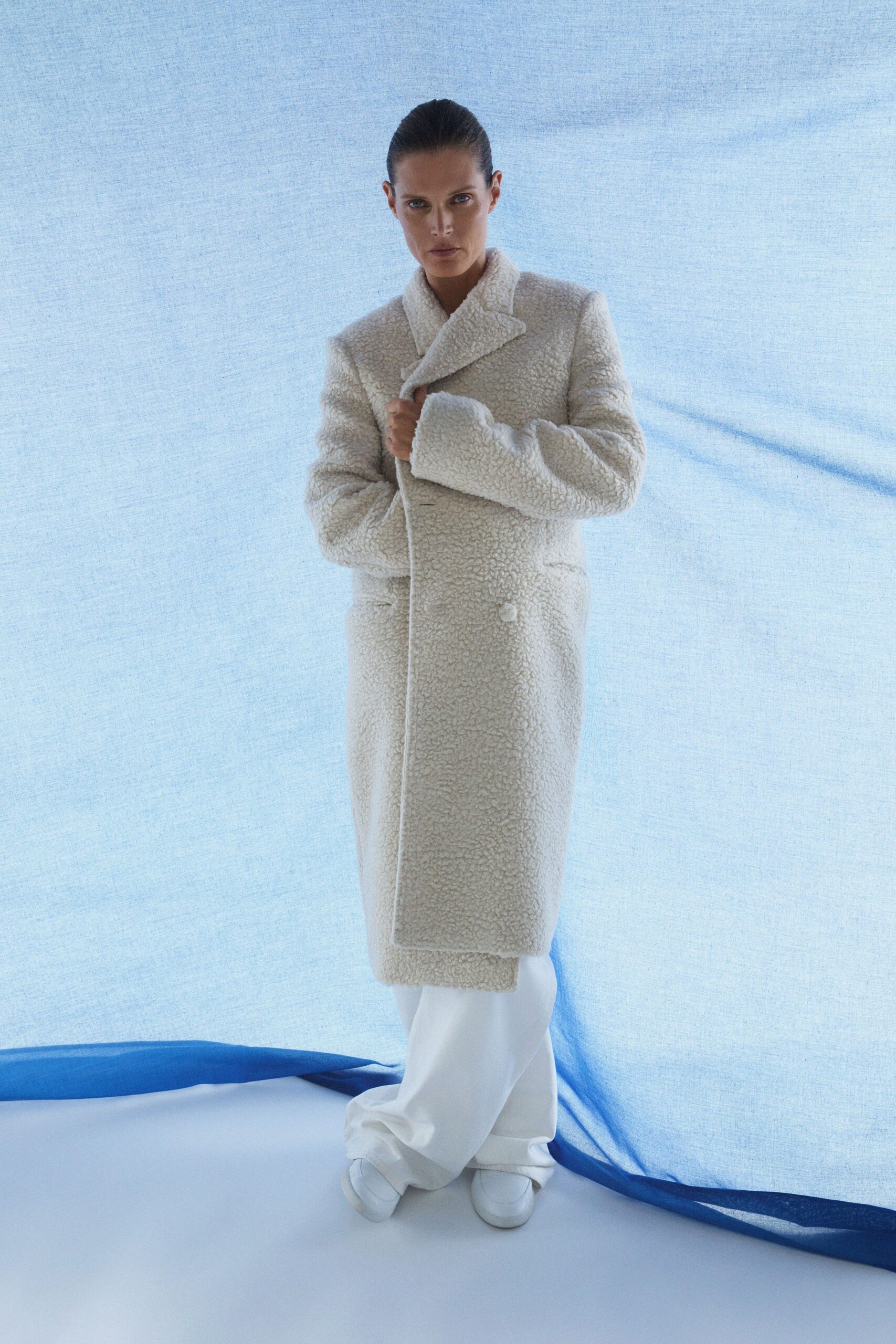 beige faux-fur coat with white pants