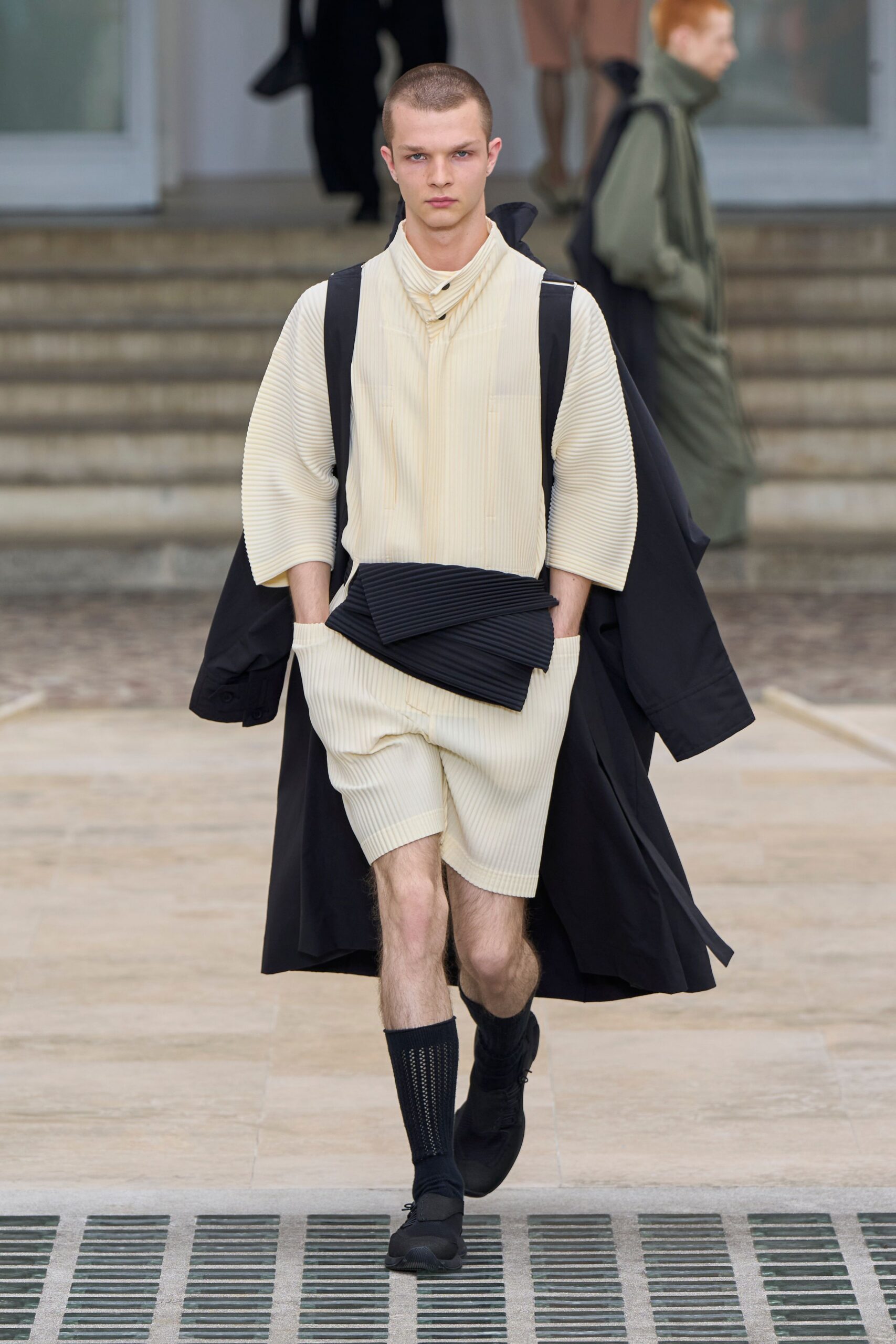black coat beige shirt shorts