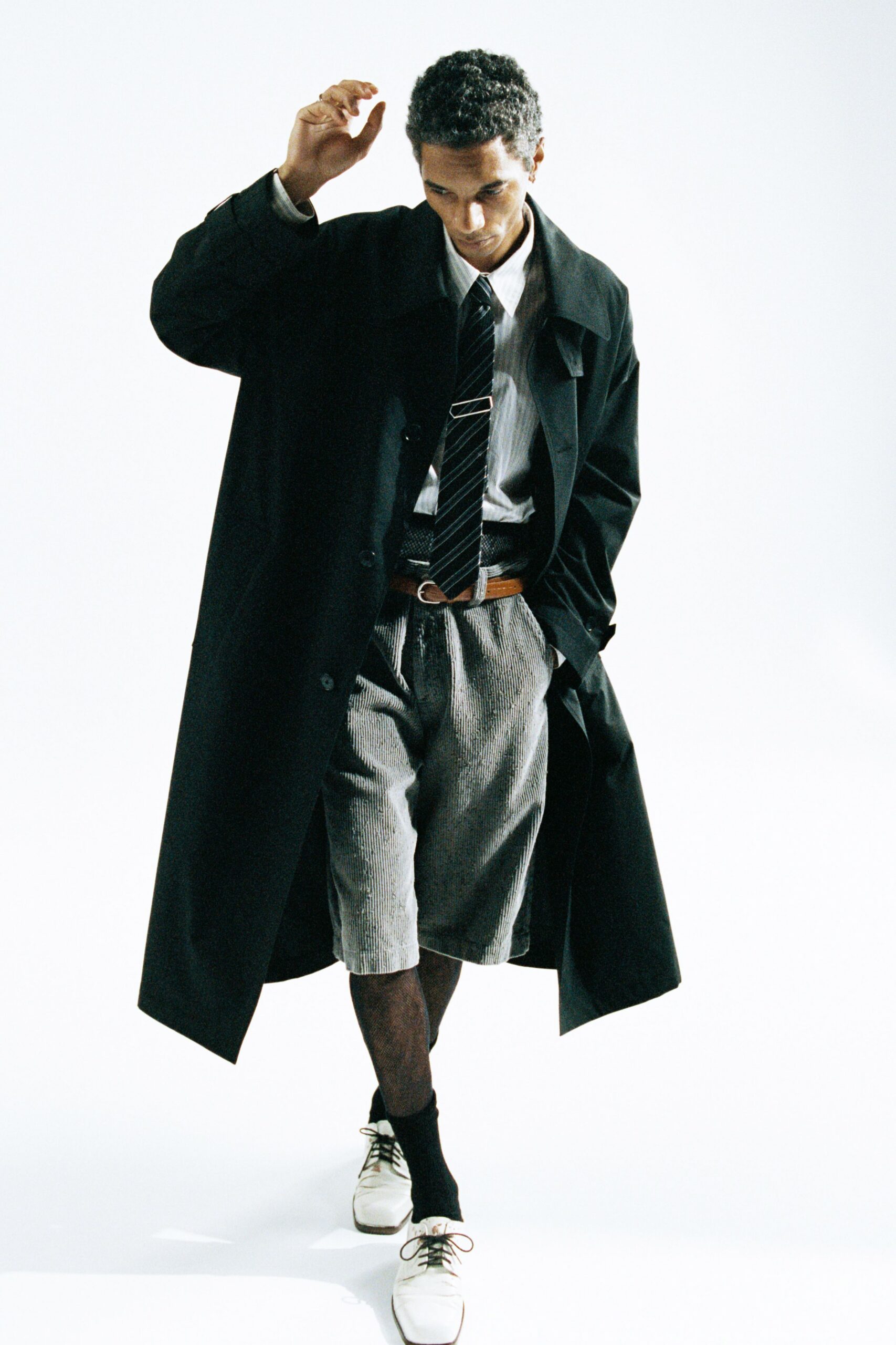 black coat white shirt gray shorts