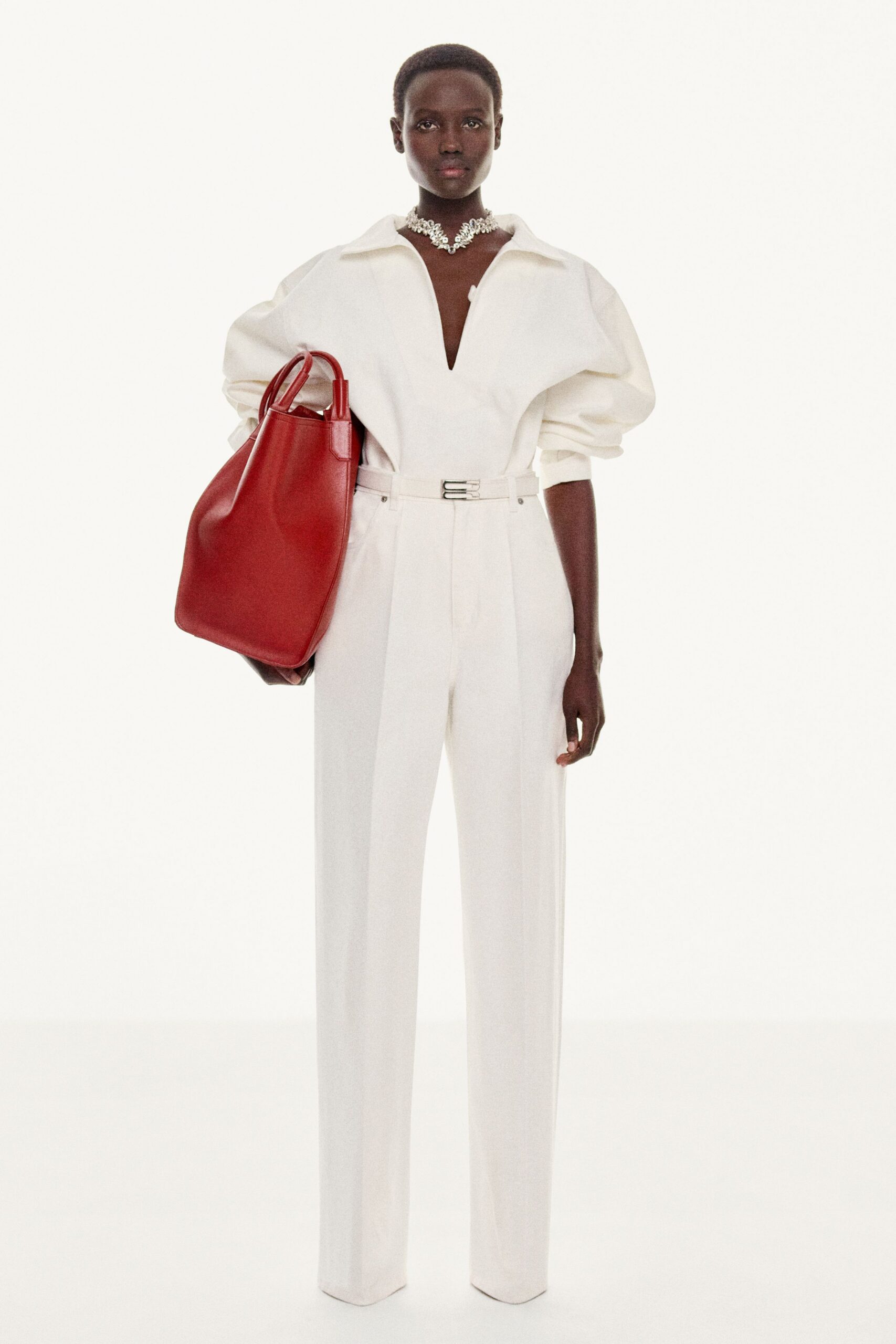 white fitted jumpsuit with red bag