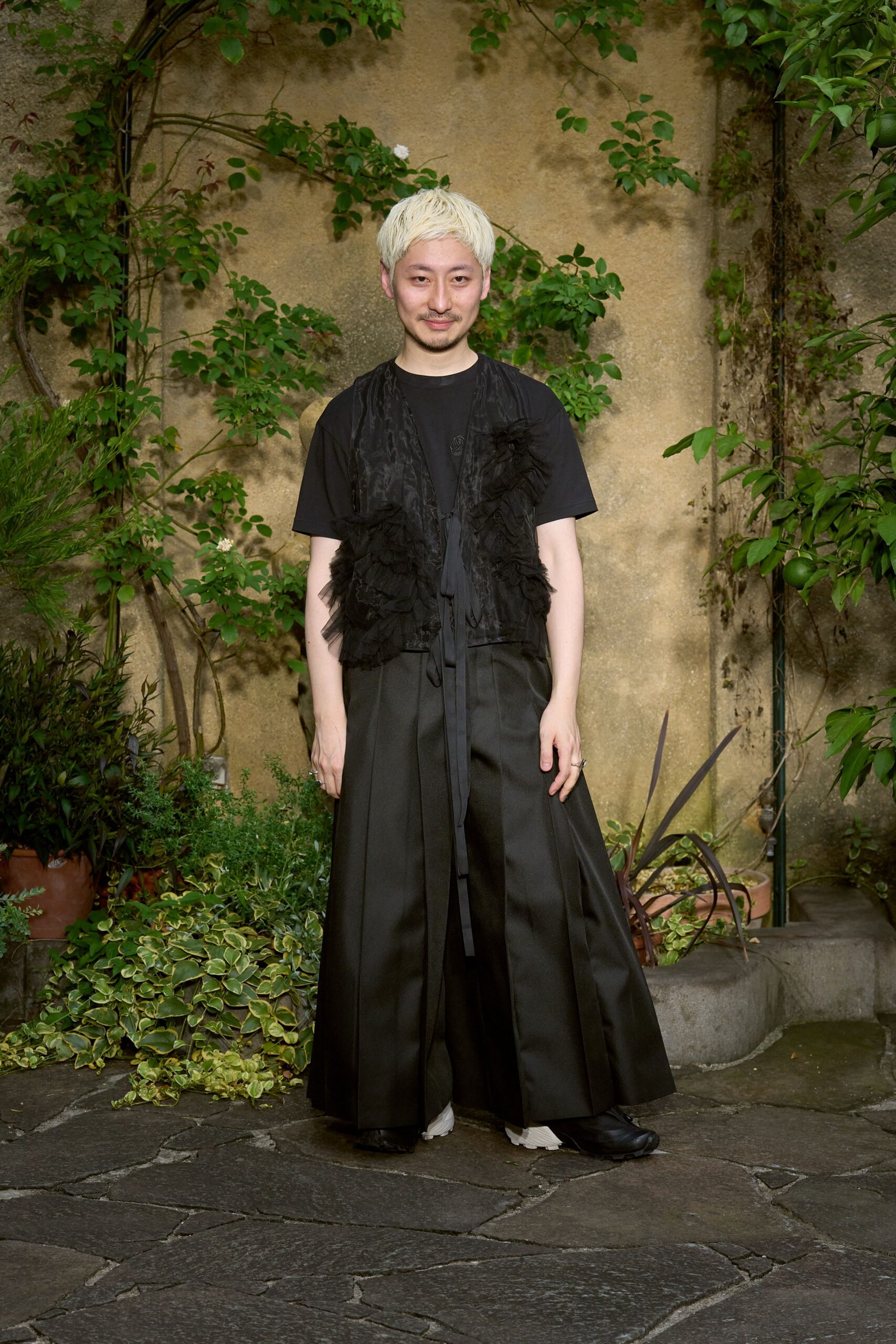 black top with fringed vest and wide-leg pants