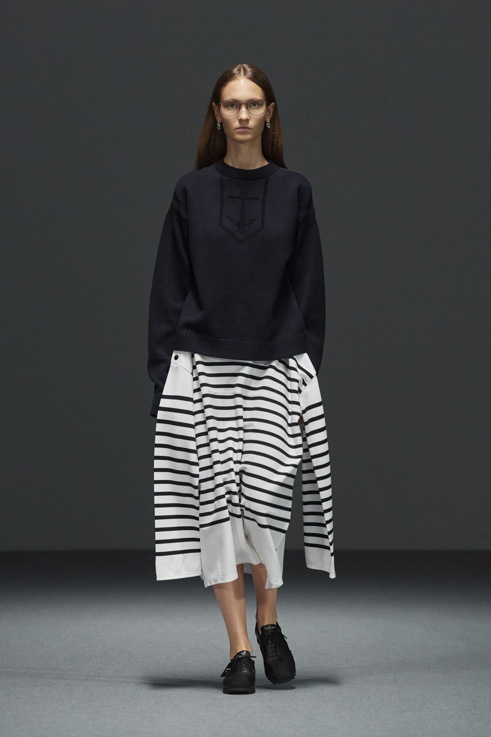black sweater and striped skirt