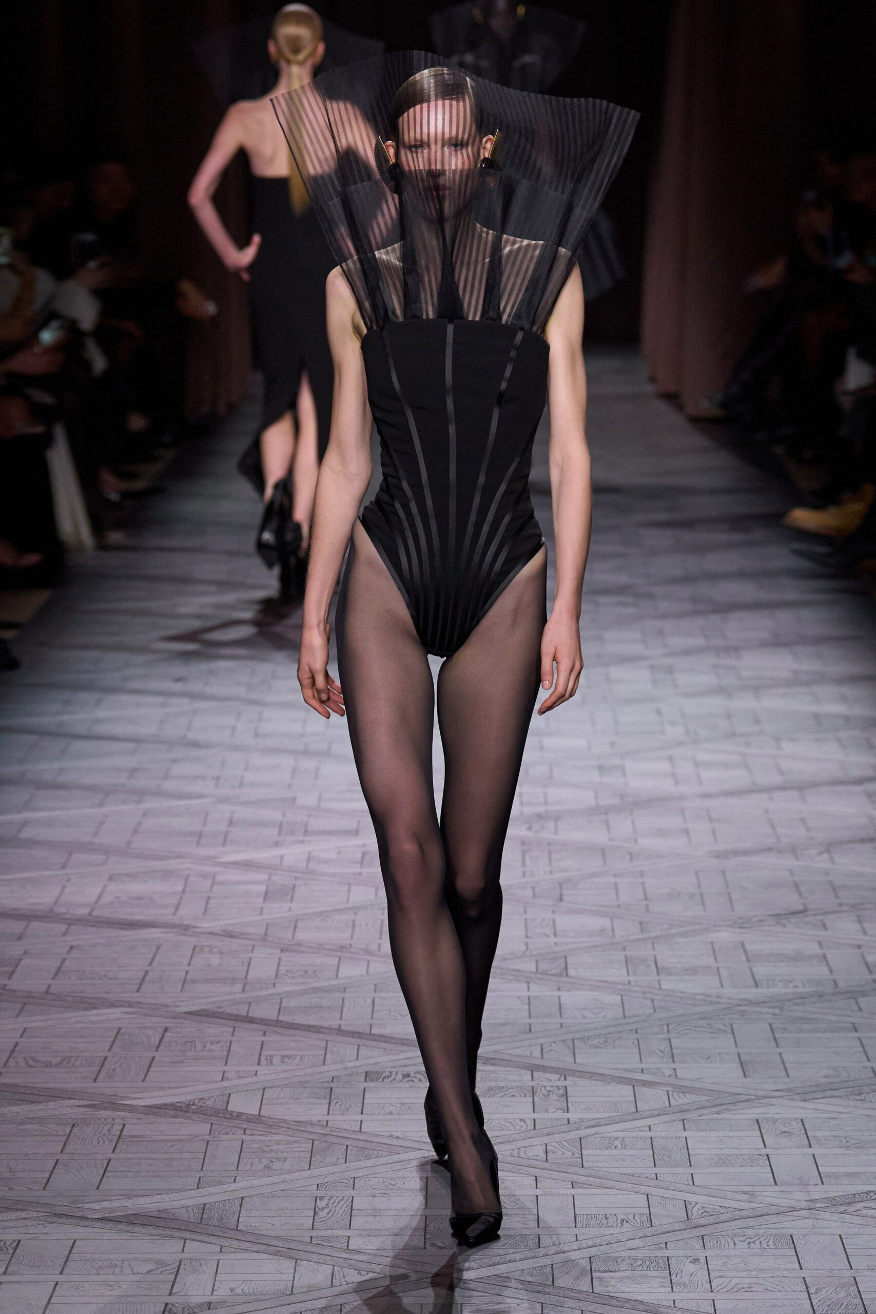 black pleated bodysuit with pointed shoes