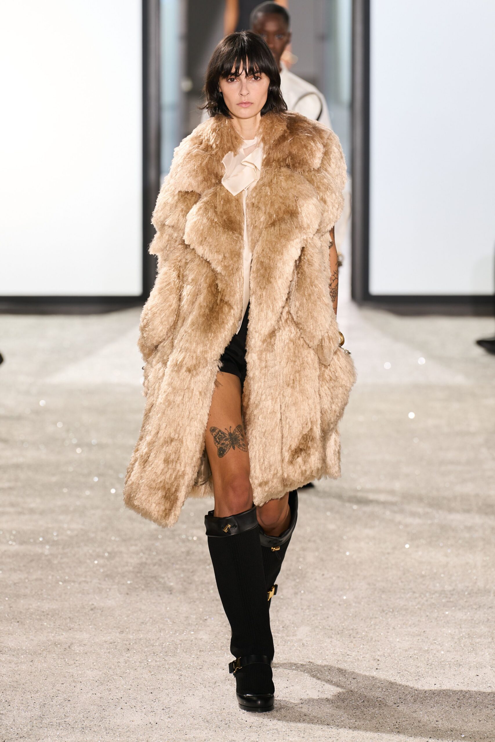 beige faux-fur coat with black shorts