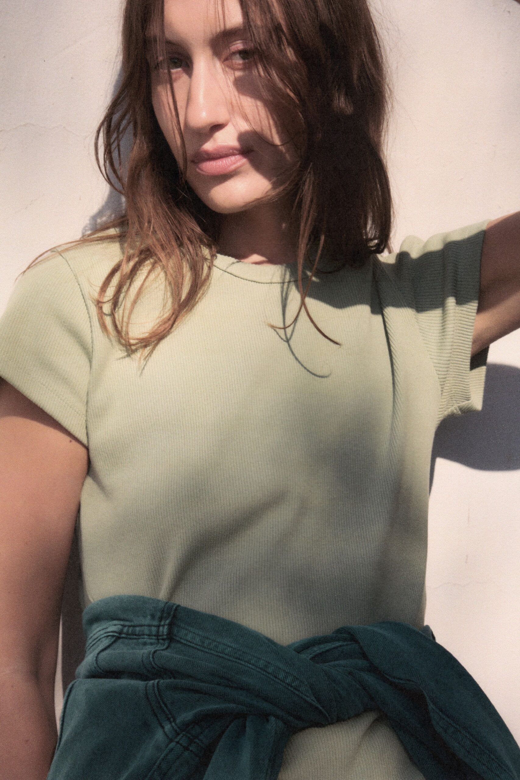 green fitted t-shirt with blue denim pants