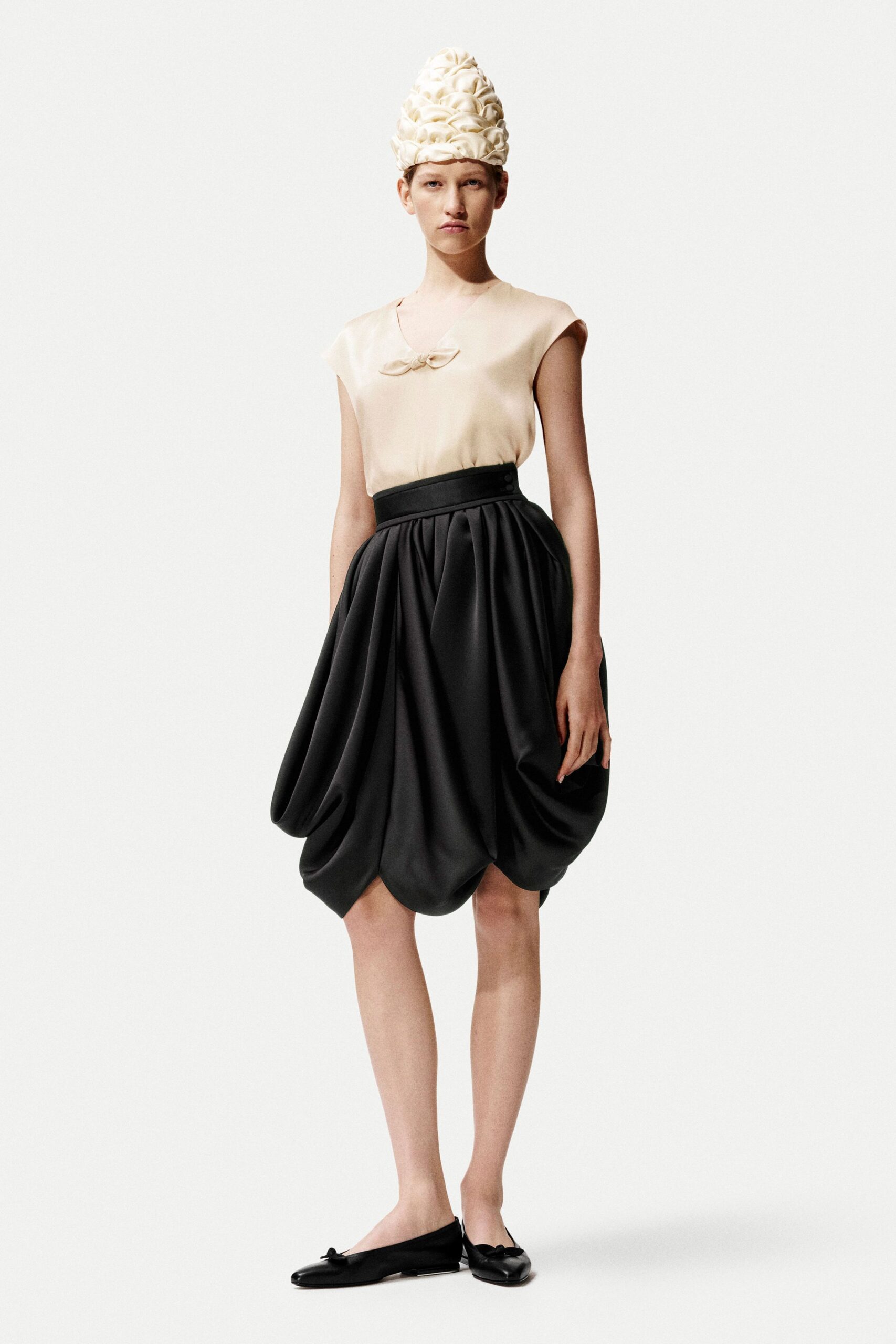 beige silk top black pleated skirt