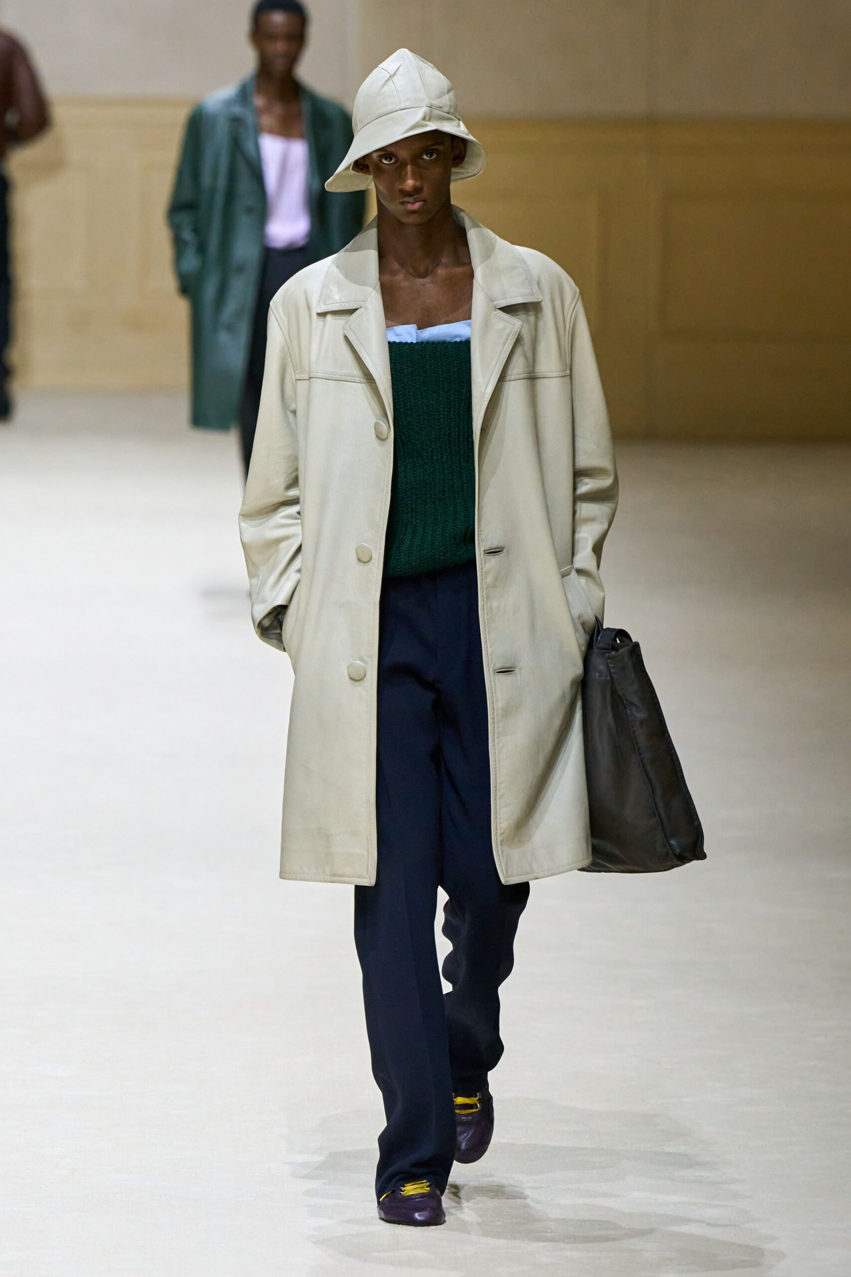 beige coat green sweater navy pants