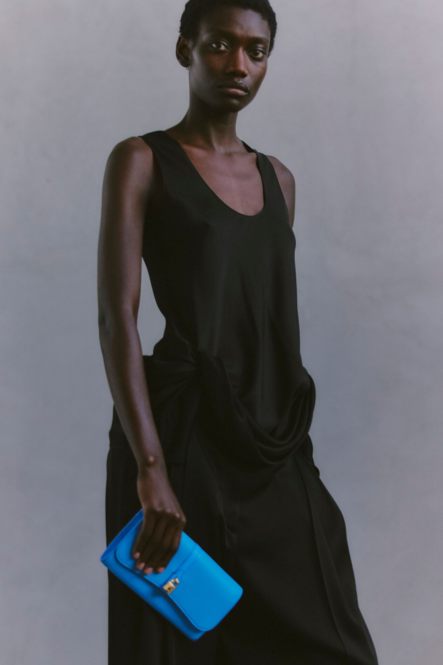 black silk sleeveless dress with blue bag