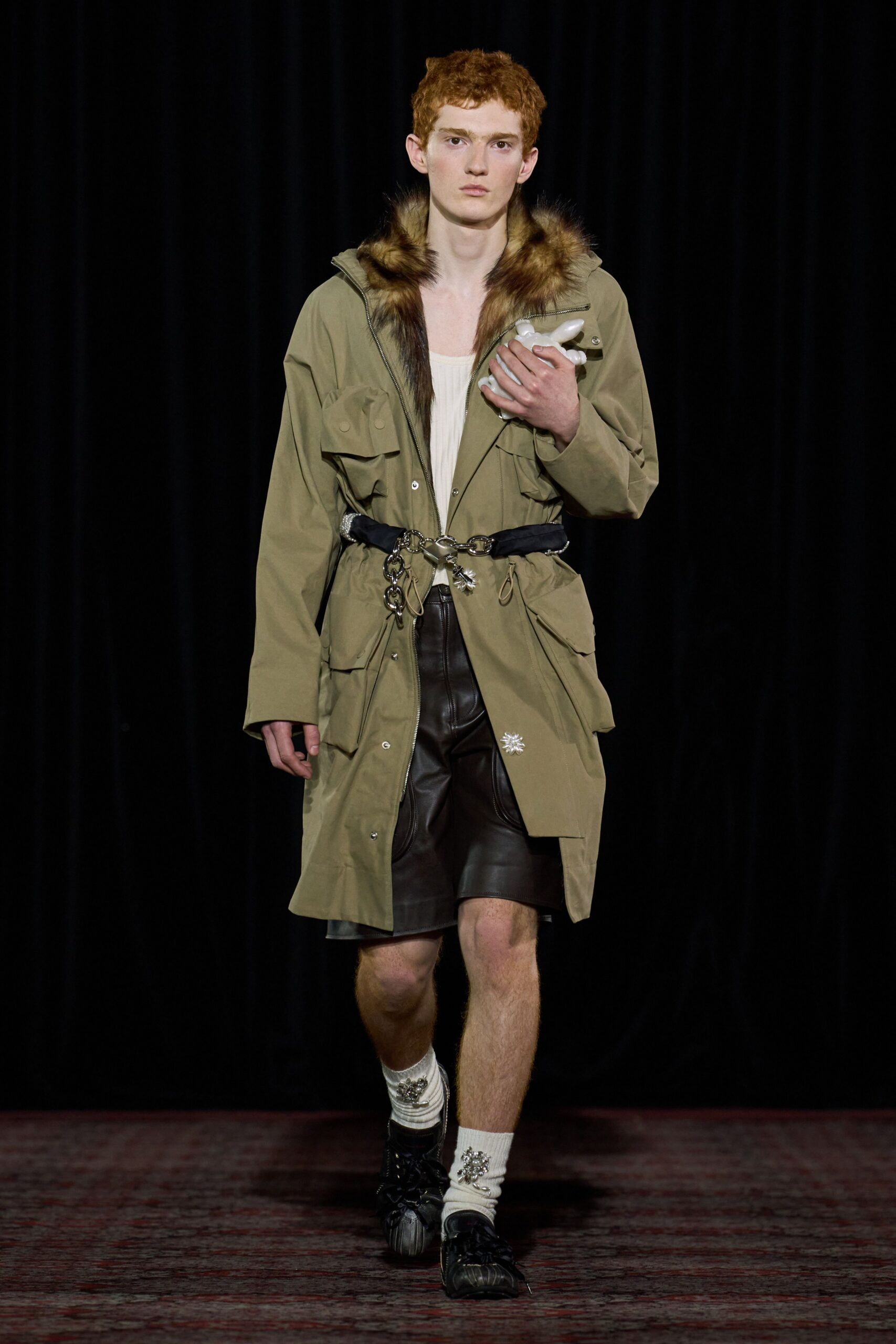 green relaxed coat with brown leather shorts