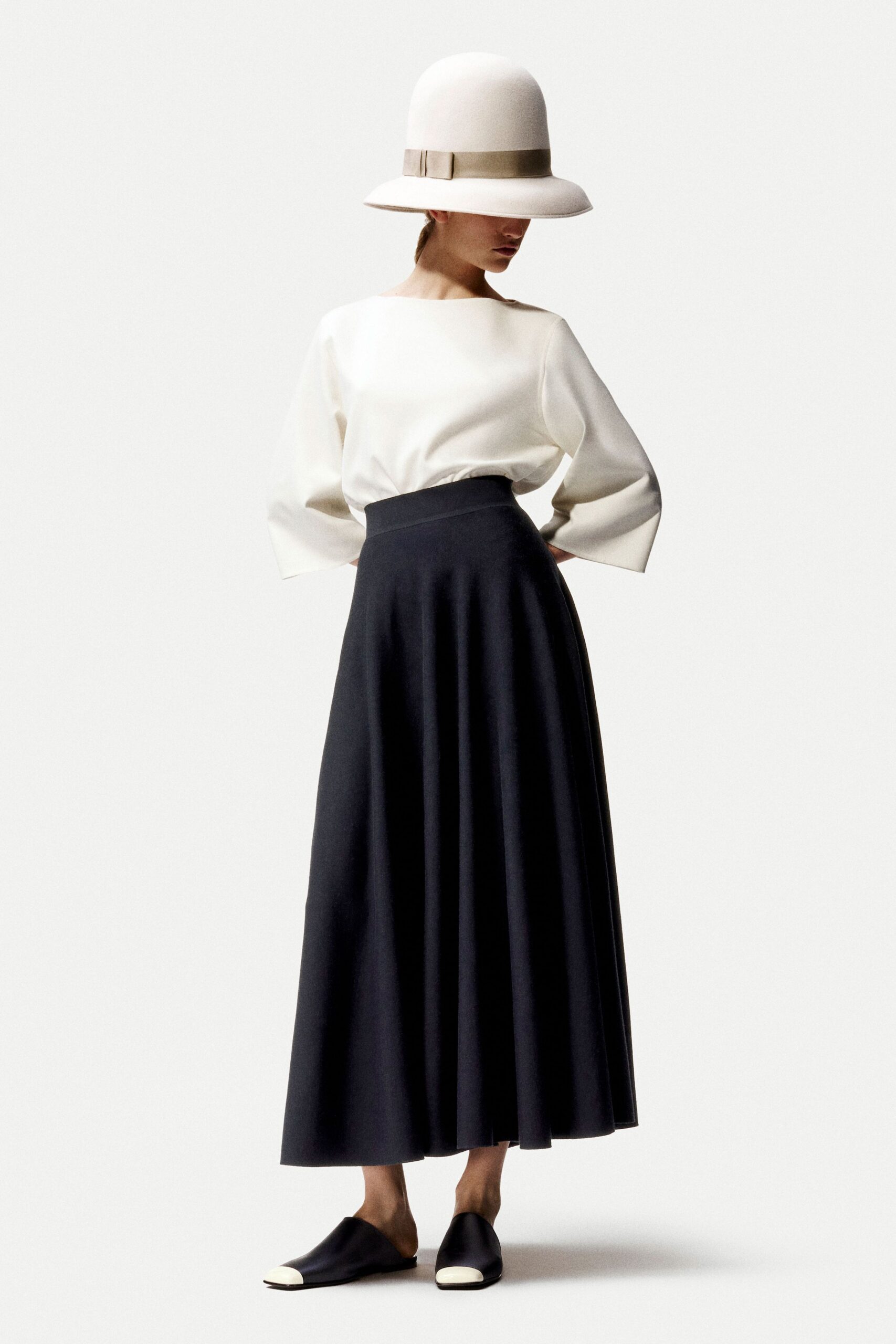 white relaxed top with black pleated skirt