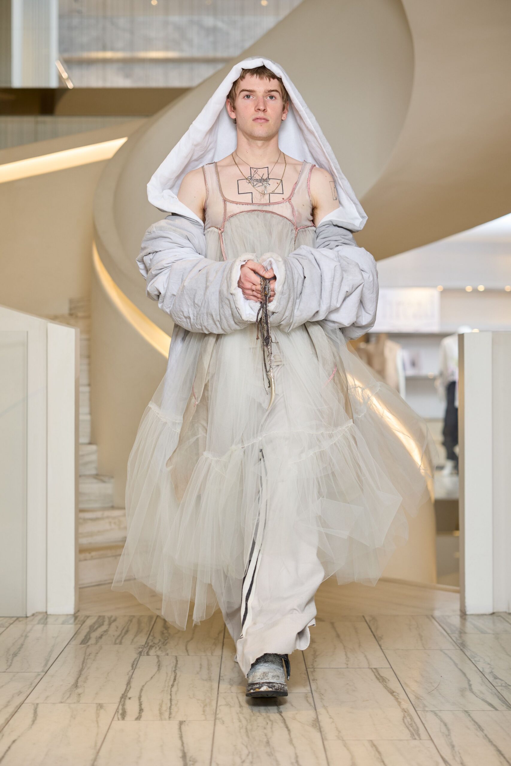 white tulle layered gown with gray oversized coat