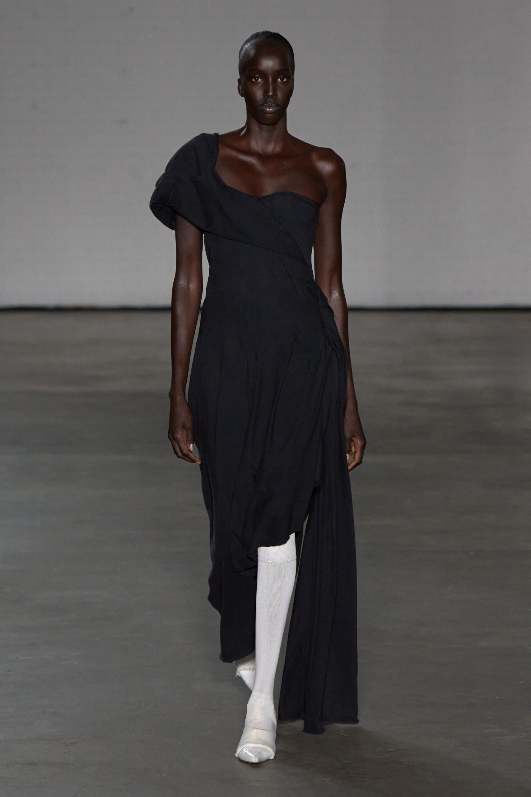 black asymmetric draped dress with white shoes