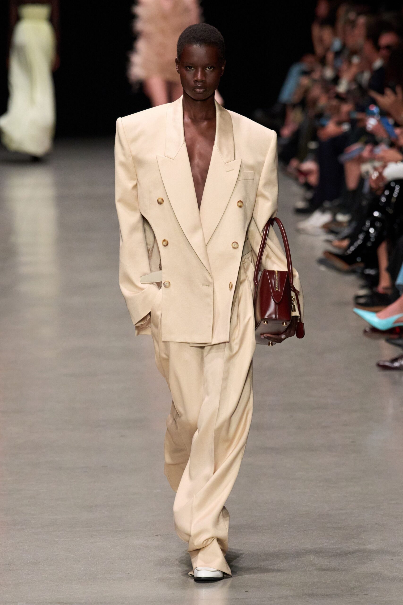 beige tailored suit with red bag